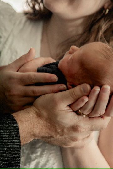 Indoor lifestyle family photography session with parents and newborn in Omaha, Nebraska