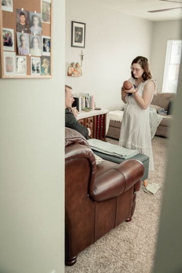 Indoor lifestyle family photography session with parents and newborn in Omaha, Nebraska