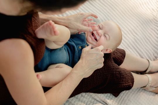 Outdoor family photography session with mother and baby laughing in Omaha, Nebraska