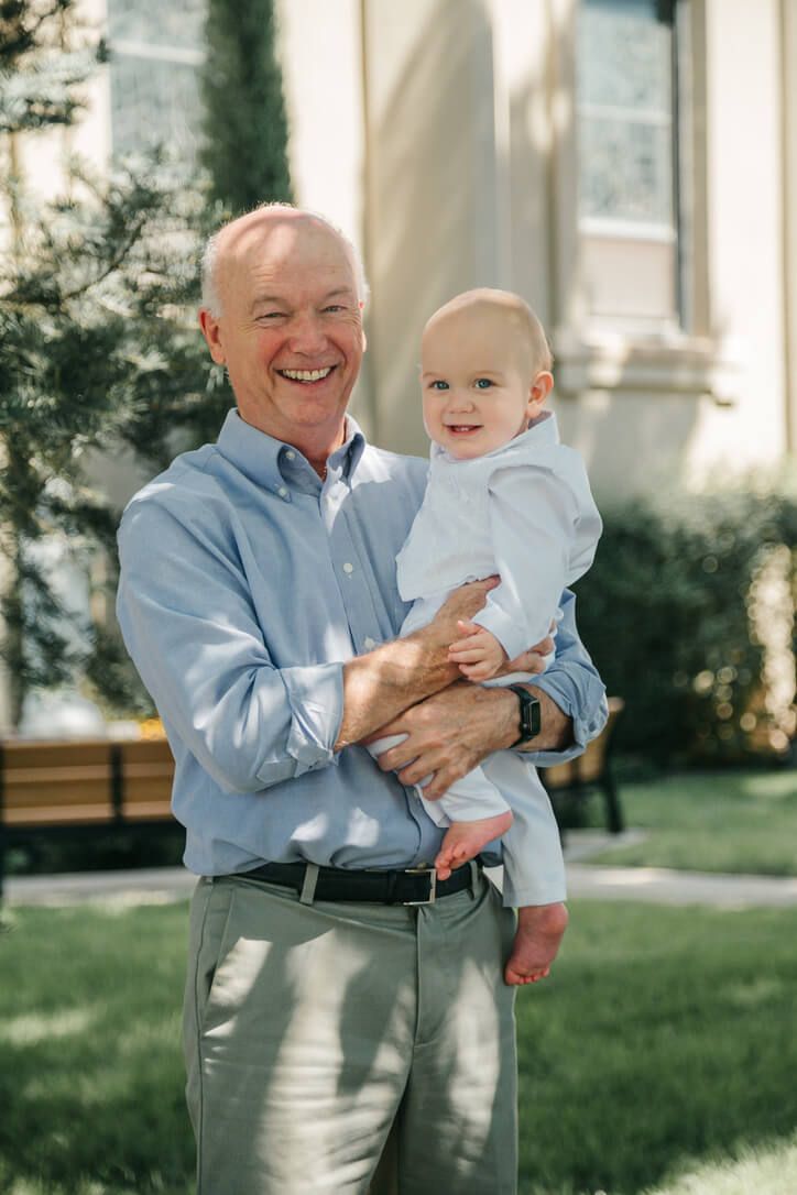 Outdoor family photography session with grandfather and grandson on baby's Catholic baptism day in Omaha, Nebraska