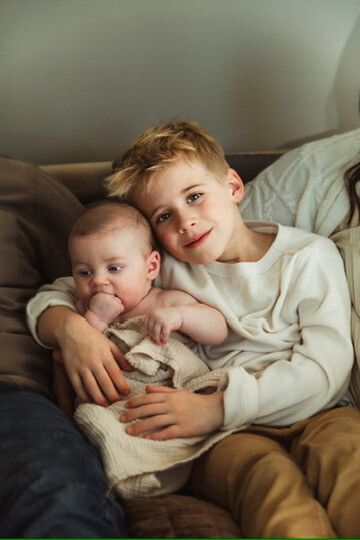 Indoor lifestyle family photography session with sibling and baby brother in Omaha, Nebraska