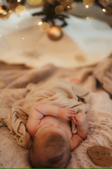 Baby boy looking at Christmas tree from family lifestyle photography session in Omaha, Nebraska