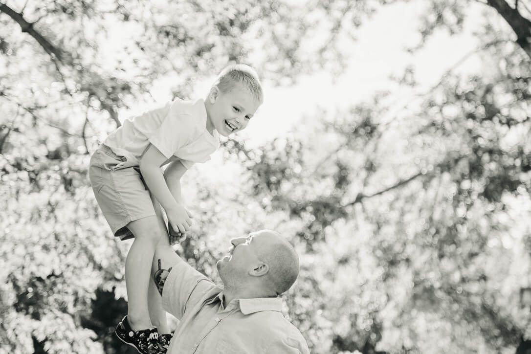 Outdoor family photography session with father and son laughing and playing in Omaha, Nebraska