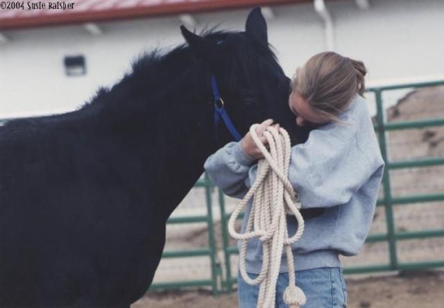 A young woman hugs a weanling.