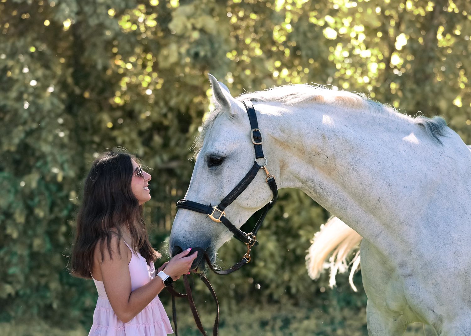 A young woman poses with her horse.