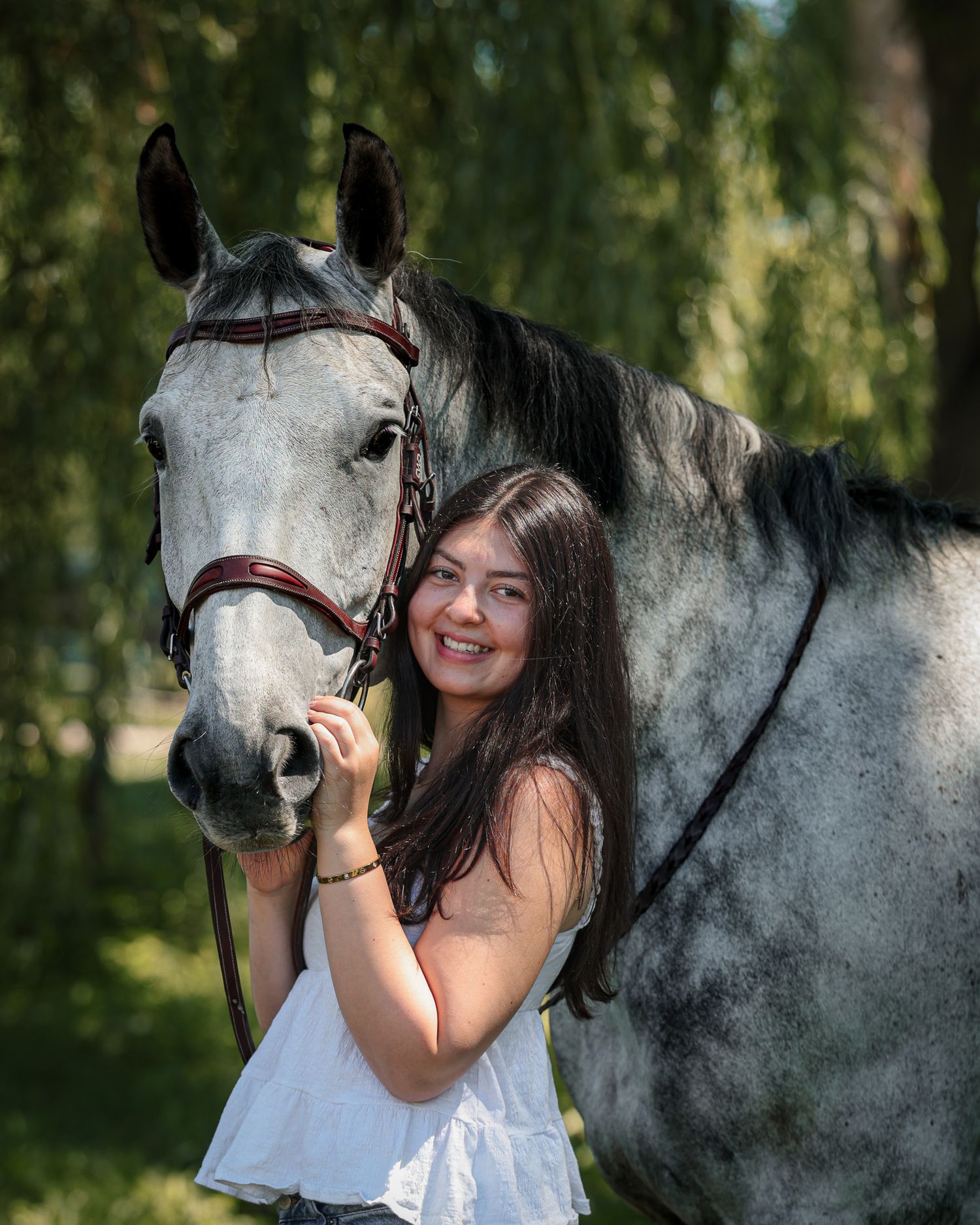 A young woman poses with her horse.