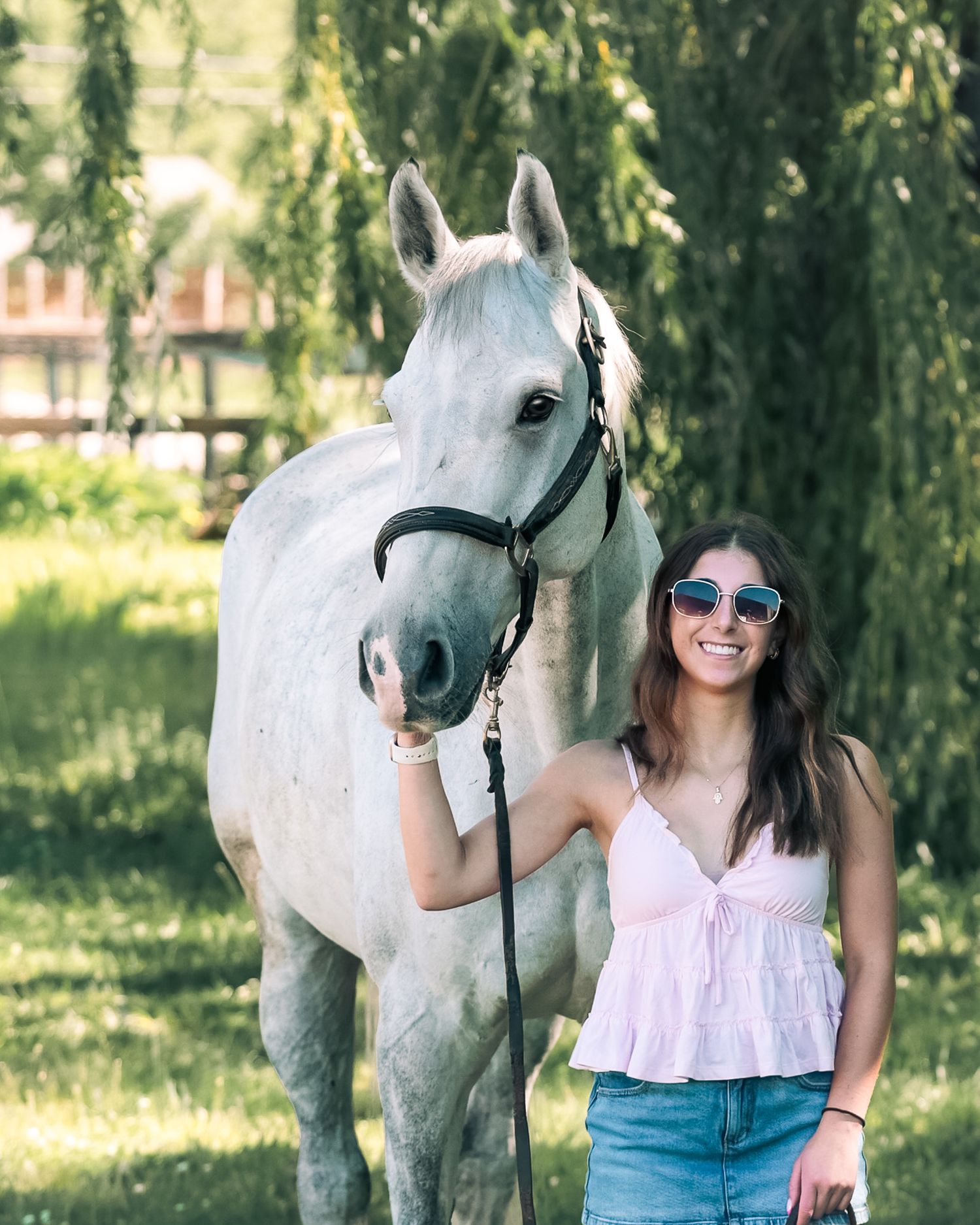 A young woman poses with her horse.
