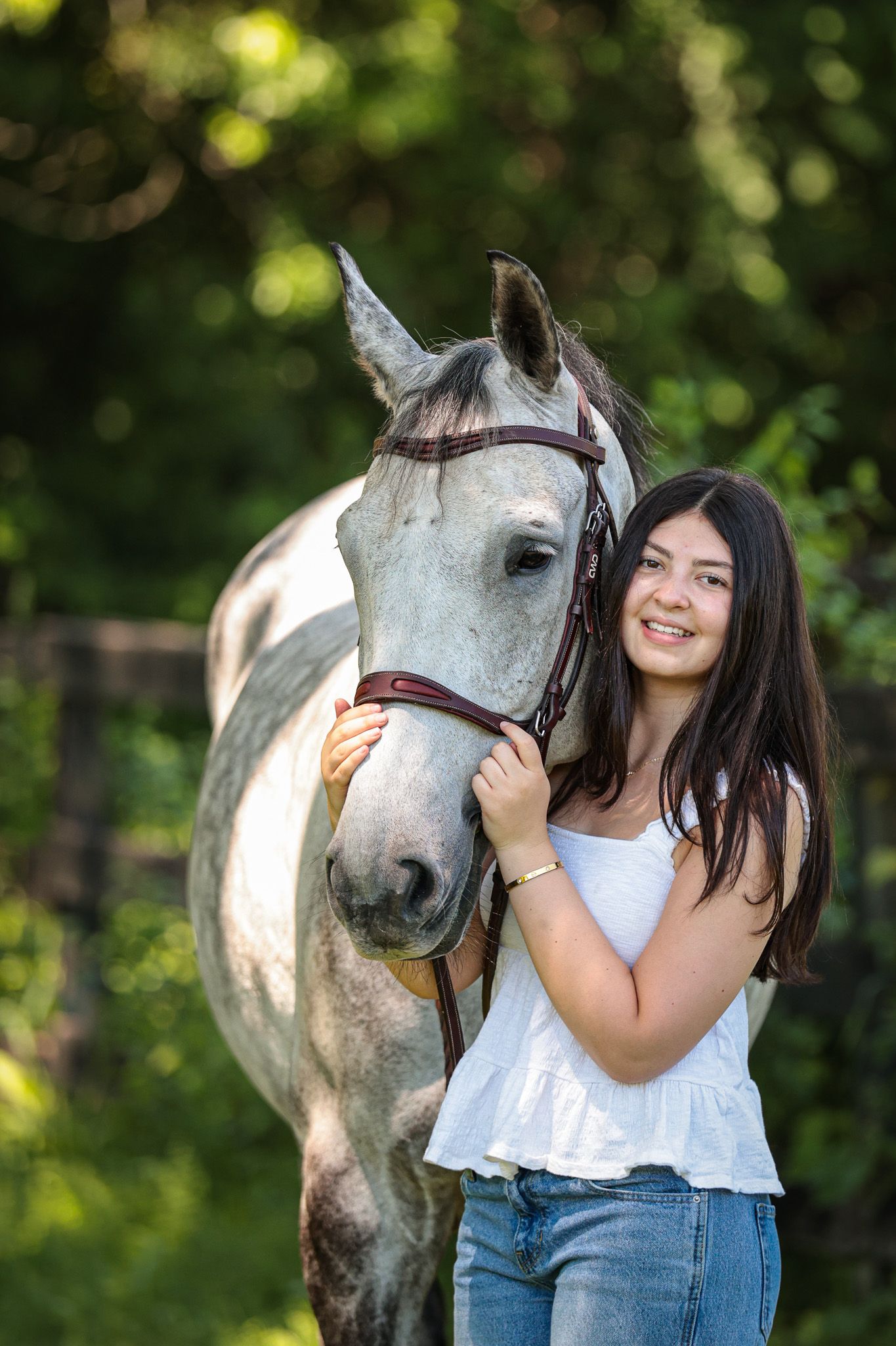 A young woman poses with her horse.