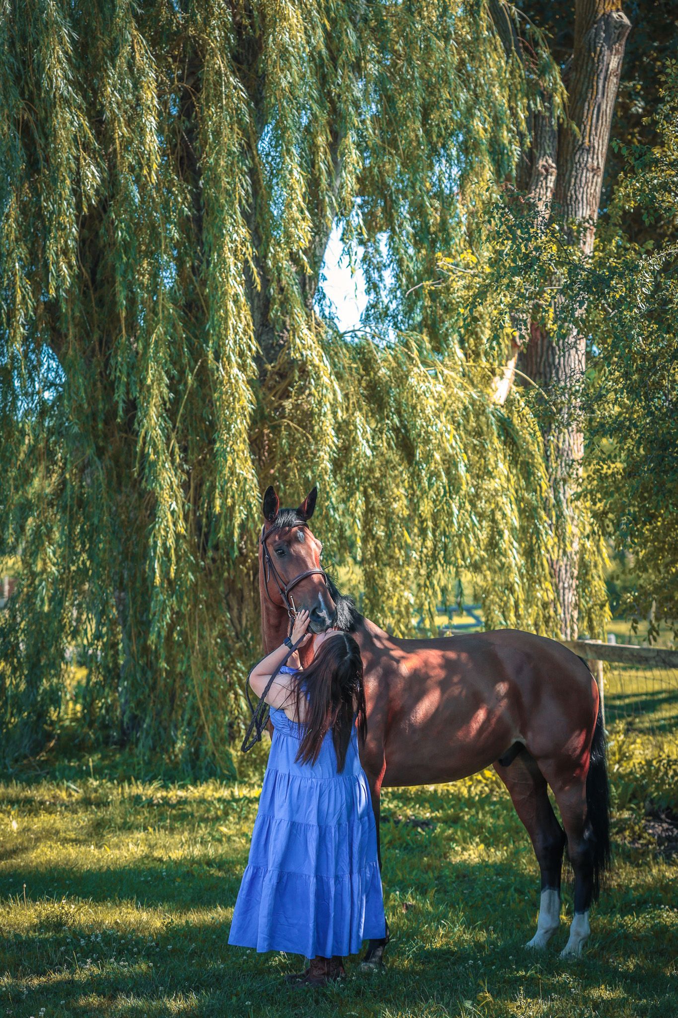 A young woman poses with her horse.