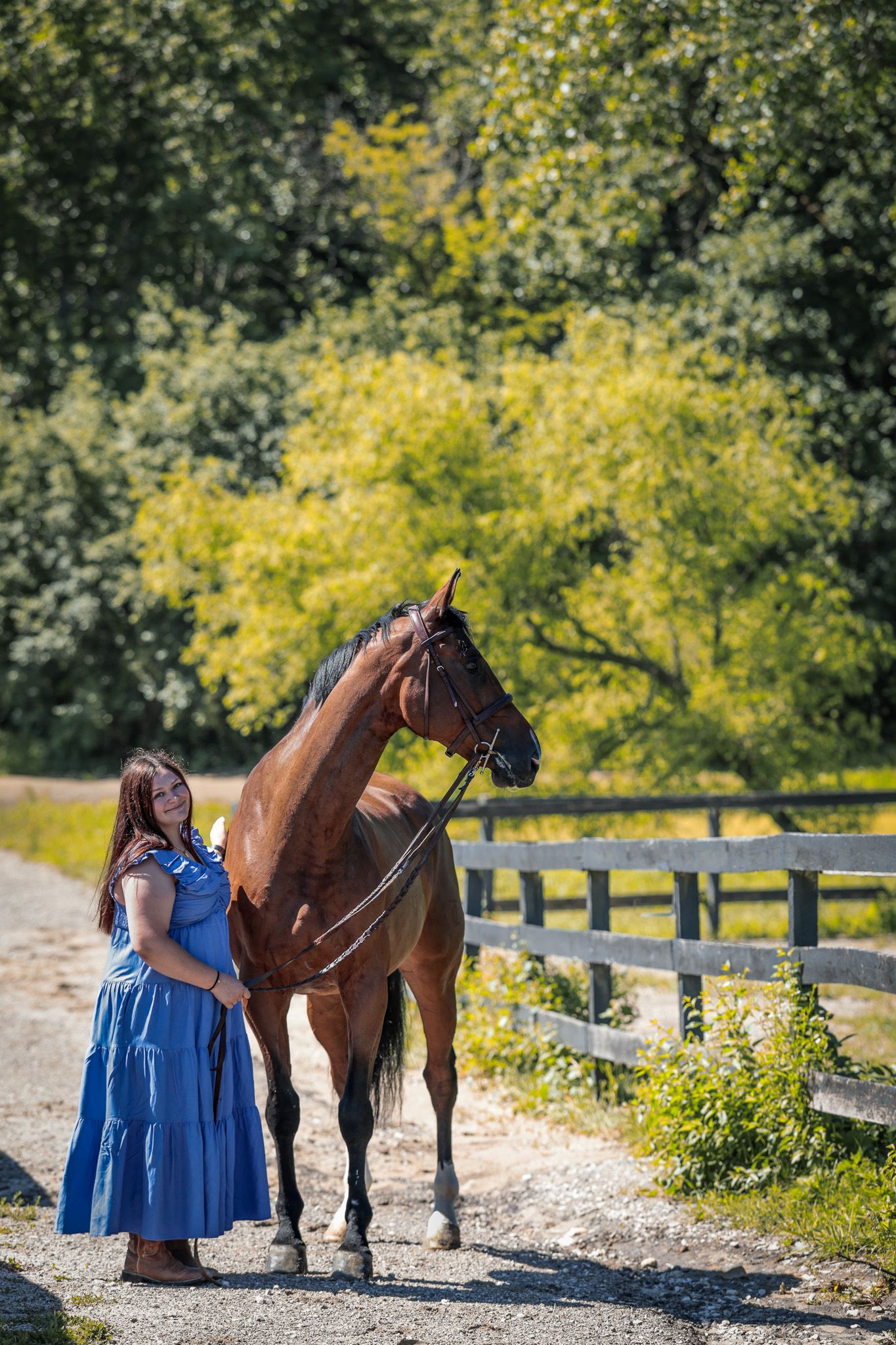 A young woman poses with her horse.