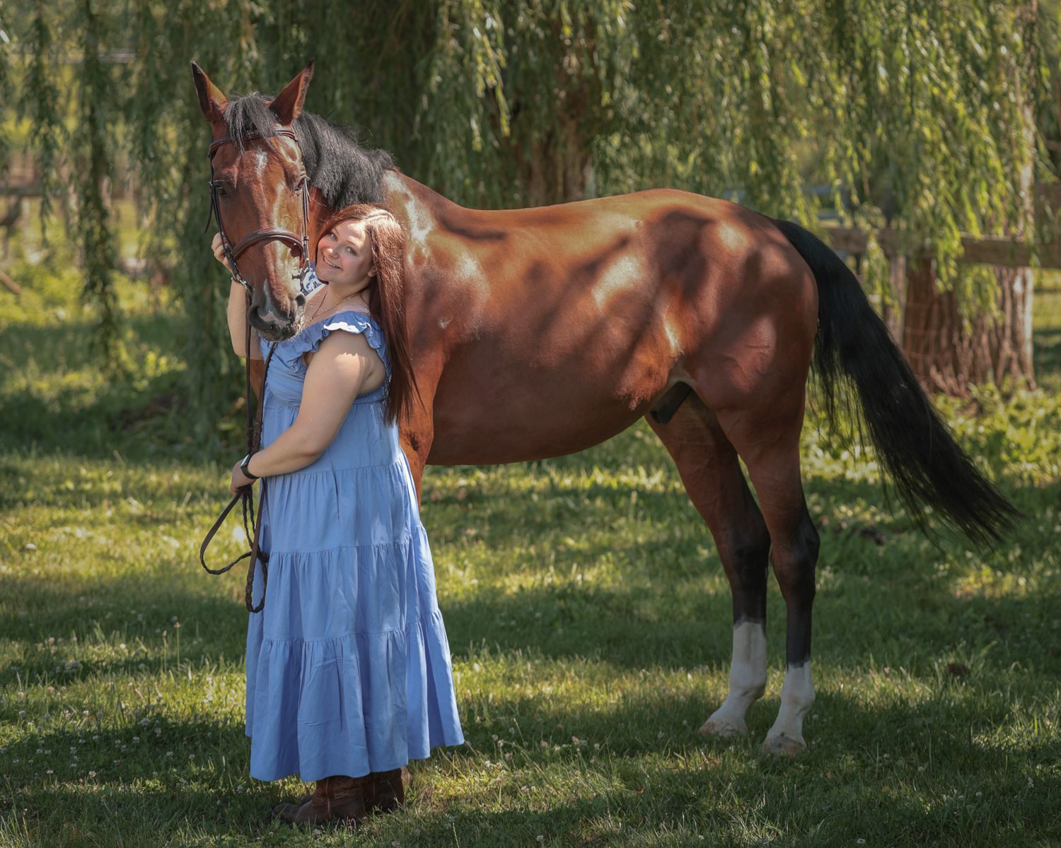 A young woman poses with her horse.