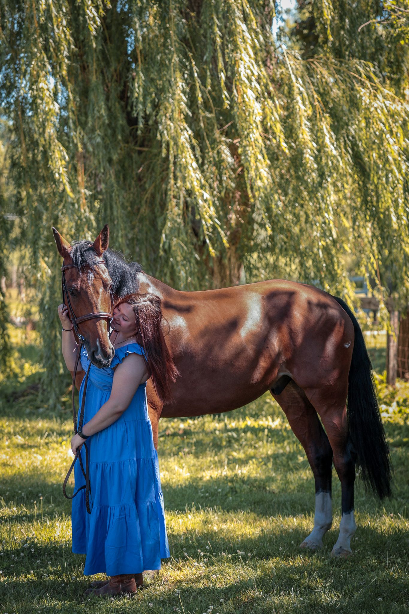 A young woman poses with her horse.