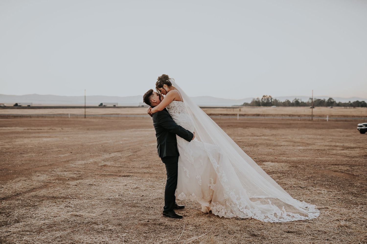Couple shares intimate moments in an open field during their wedding photo session.