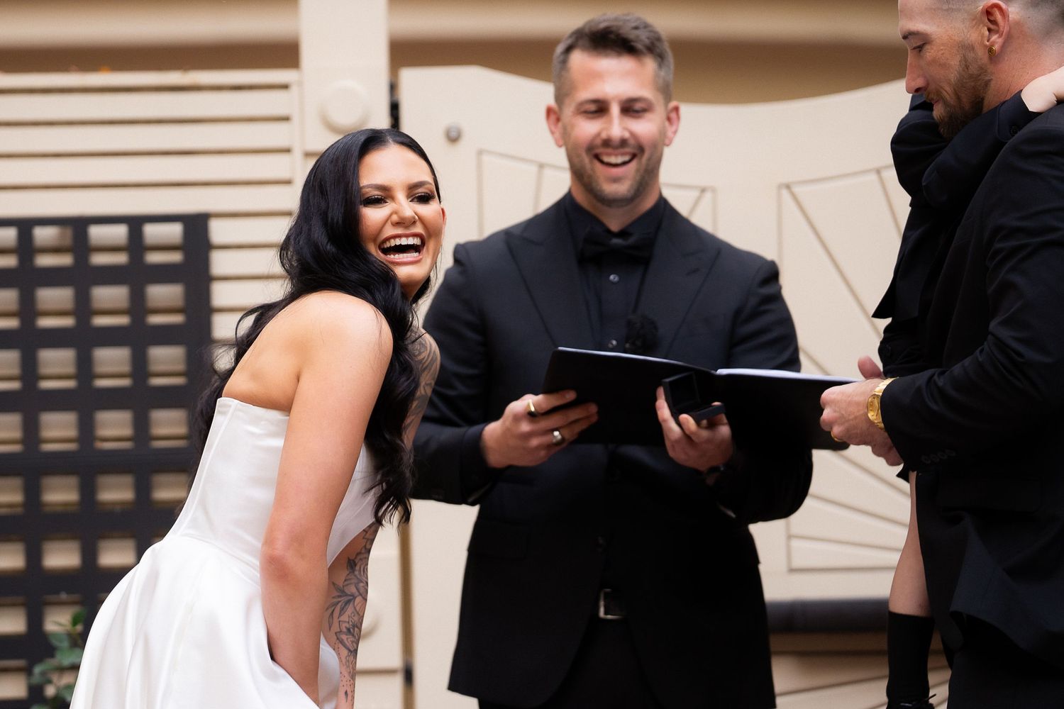 A joyful wedding ceremony moment captured outdoors with guests looking on.