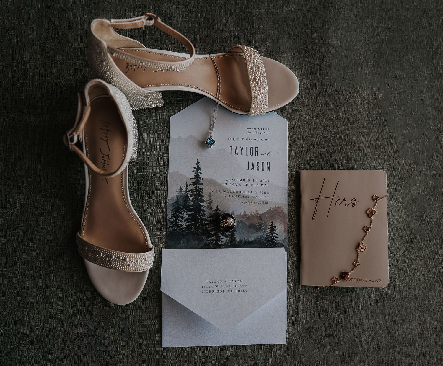 Wedding details including beige sandals and rustic invitation suite on dark background.
