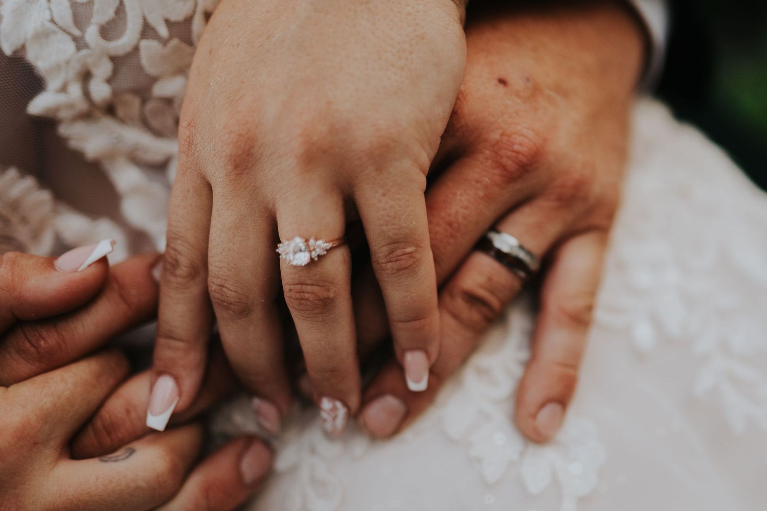 Close-up of wedding rings and hands showing intricate details.