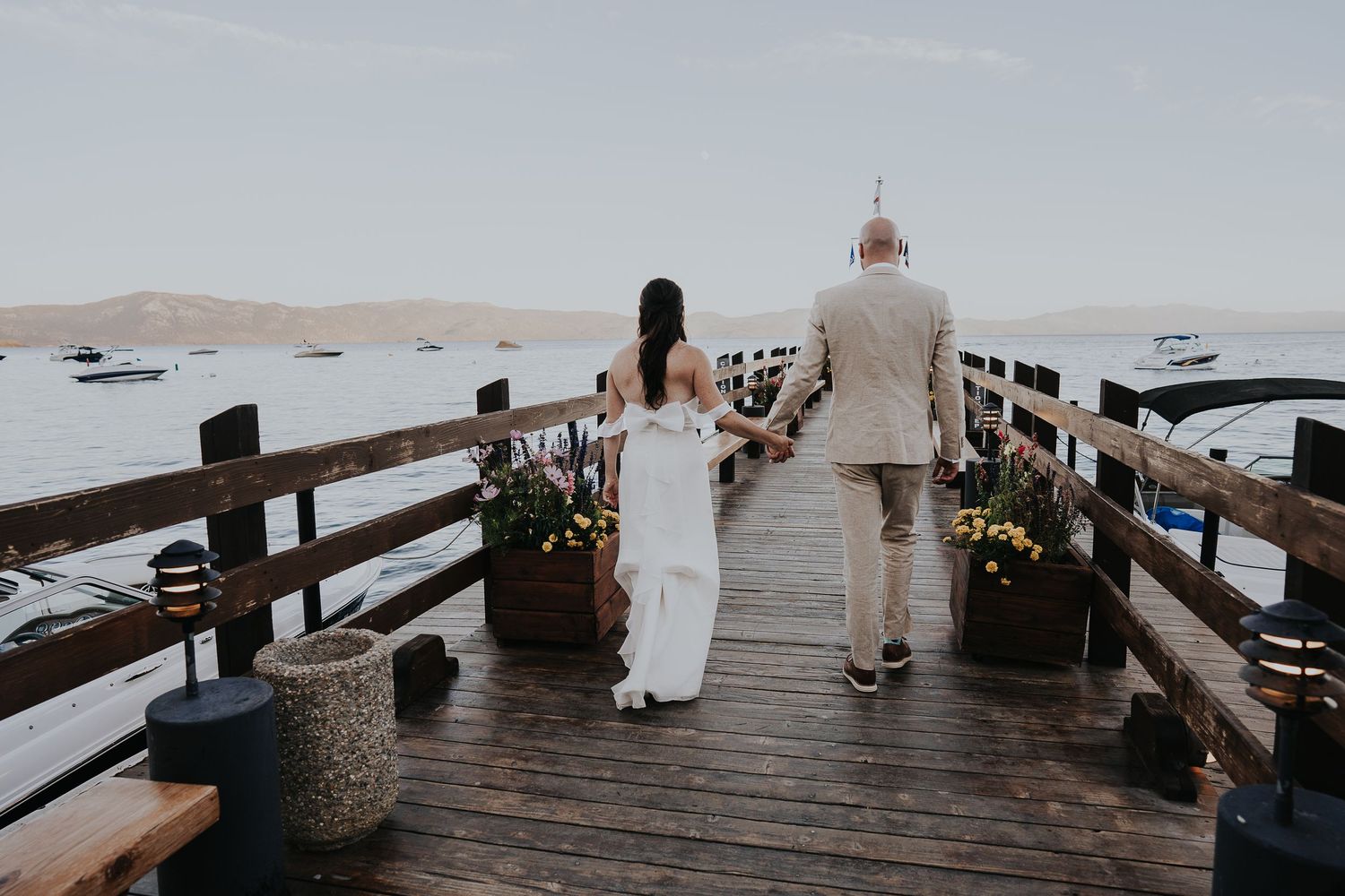 Romantic boardwalk wedding scene with wooden railings and water views.
