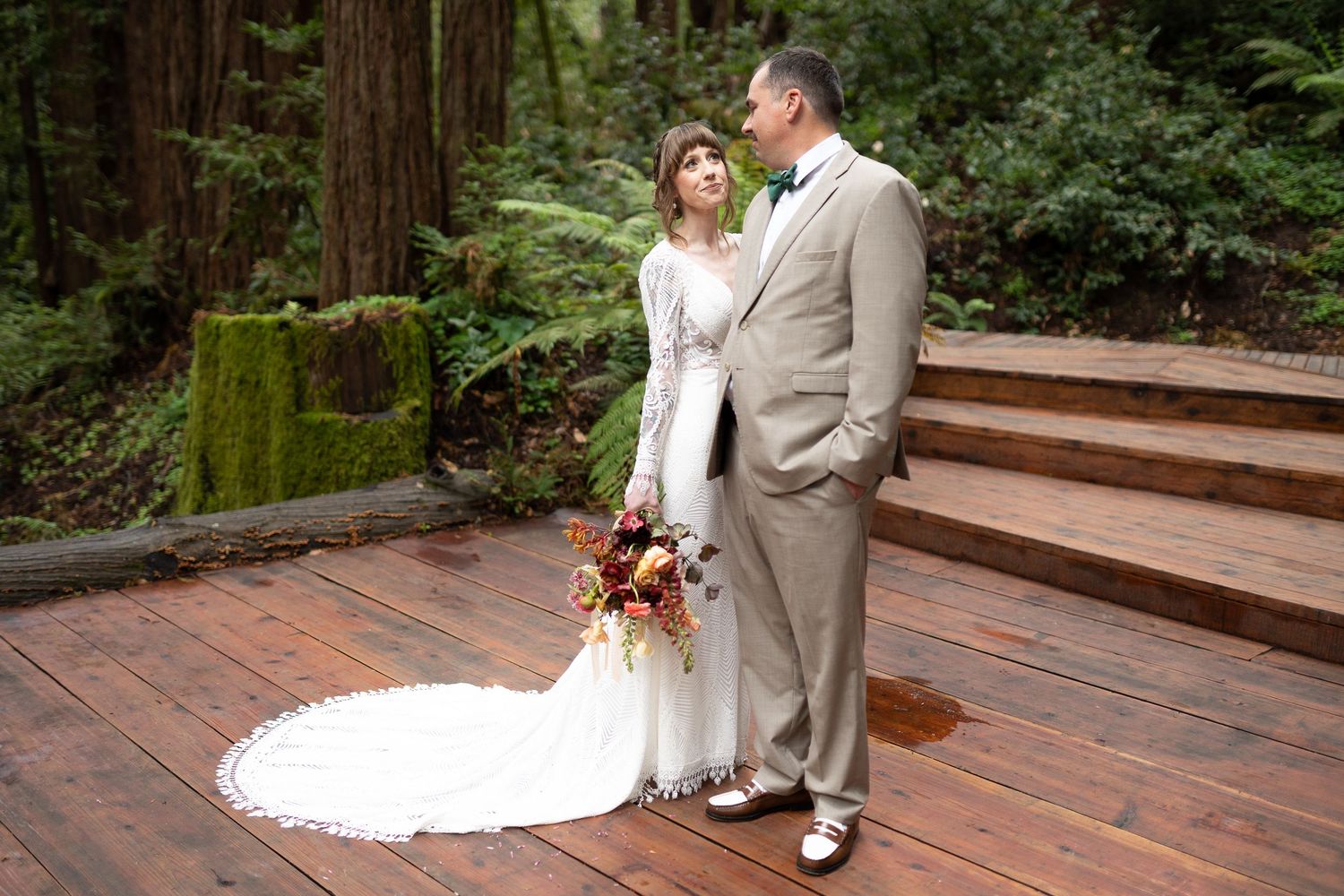 A wedding ceremony on a rustic brick patio surrounded by tall trees.
