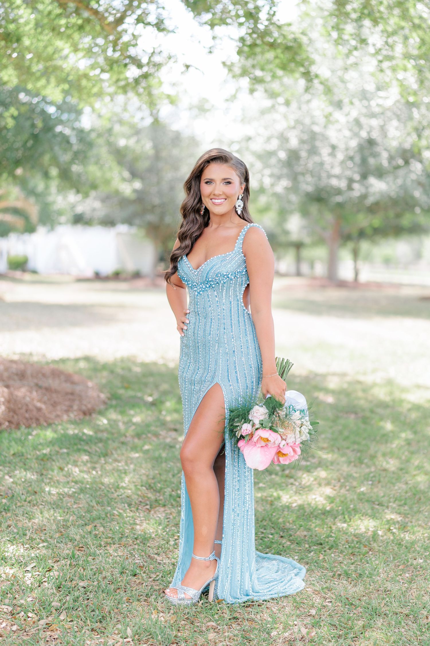 Beautiful portrait of a high school girl in her elegant prom dress holding a floral arrangement, taken by a photographer in Valdosta, GA.