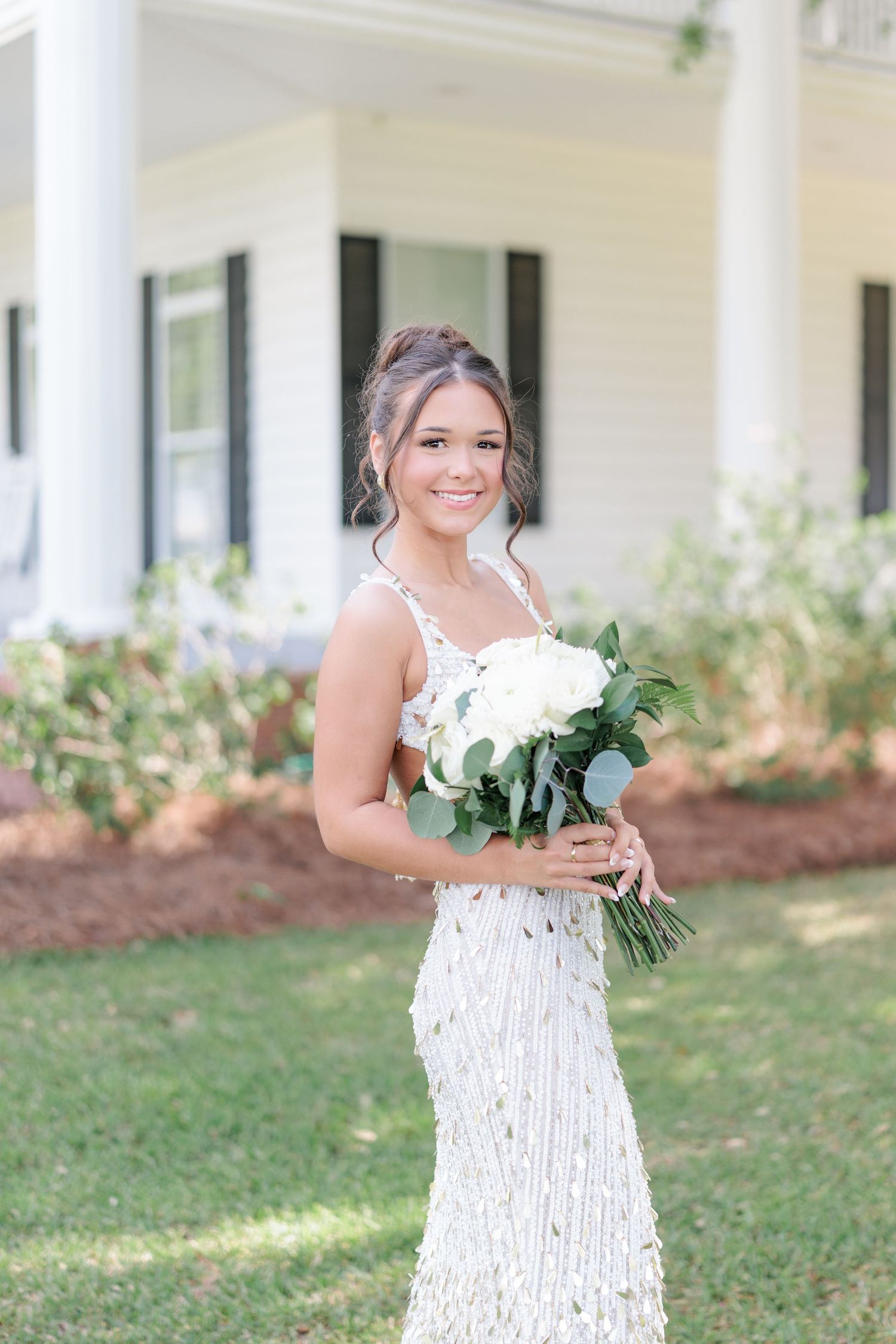 Beautiful portrait of a high school girl in her elegant prom dress holding a floral arrangement, taken by a photographer in Valdosta, GA.