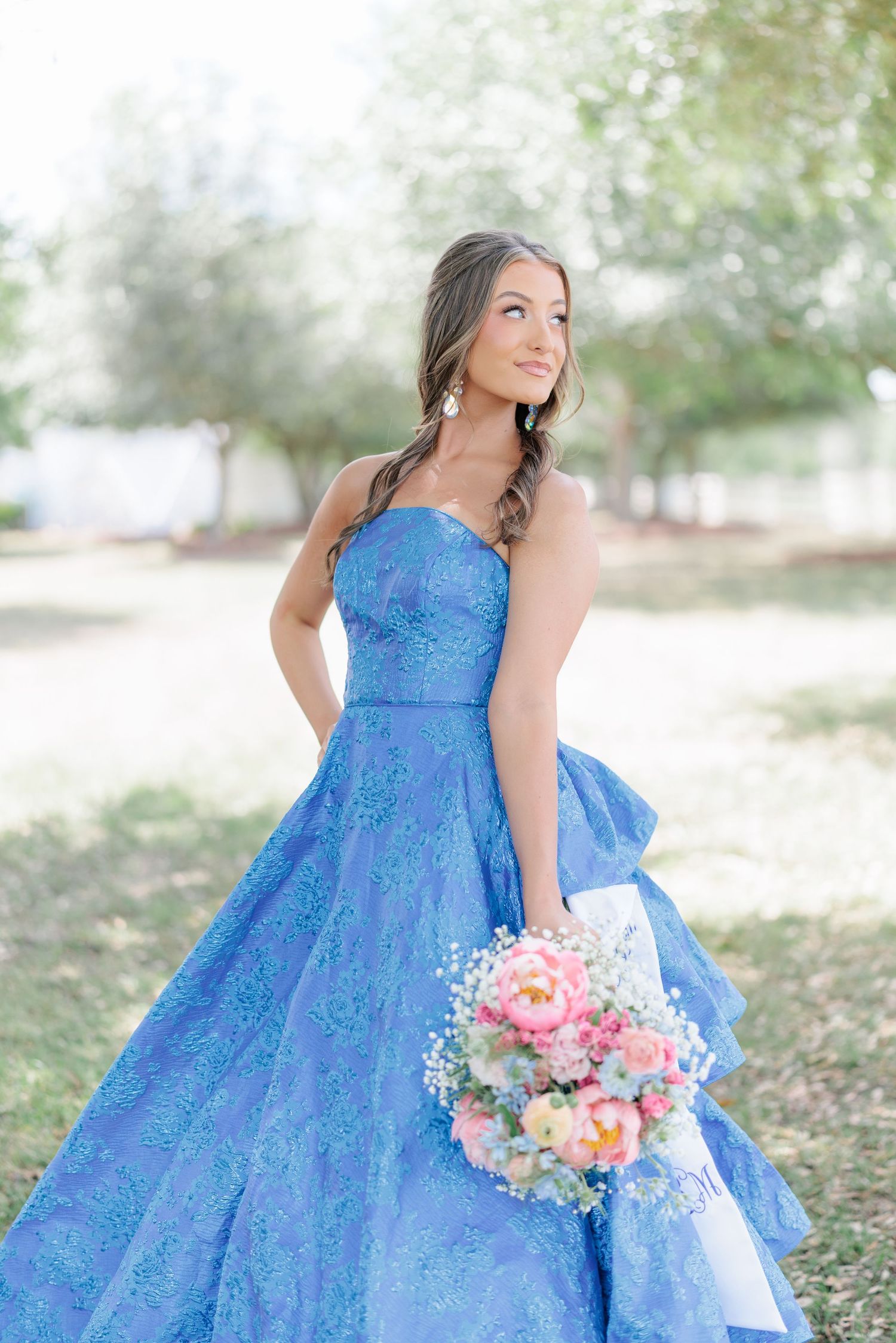 Beautiful portrait of a high school girl in her elegant prom dress holding a floral arrangement, taken by a photographer in Valdosta, GA.