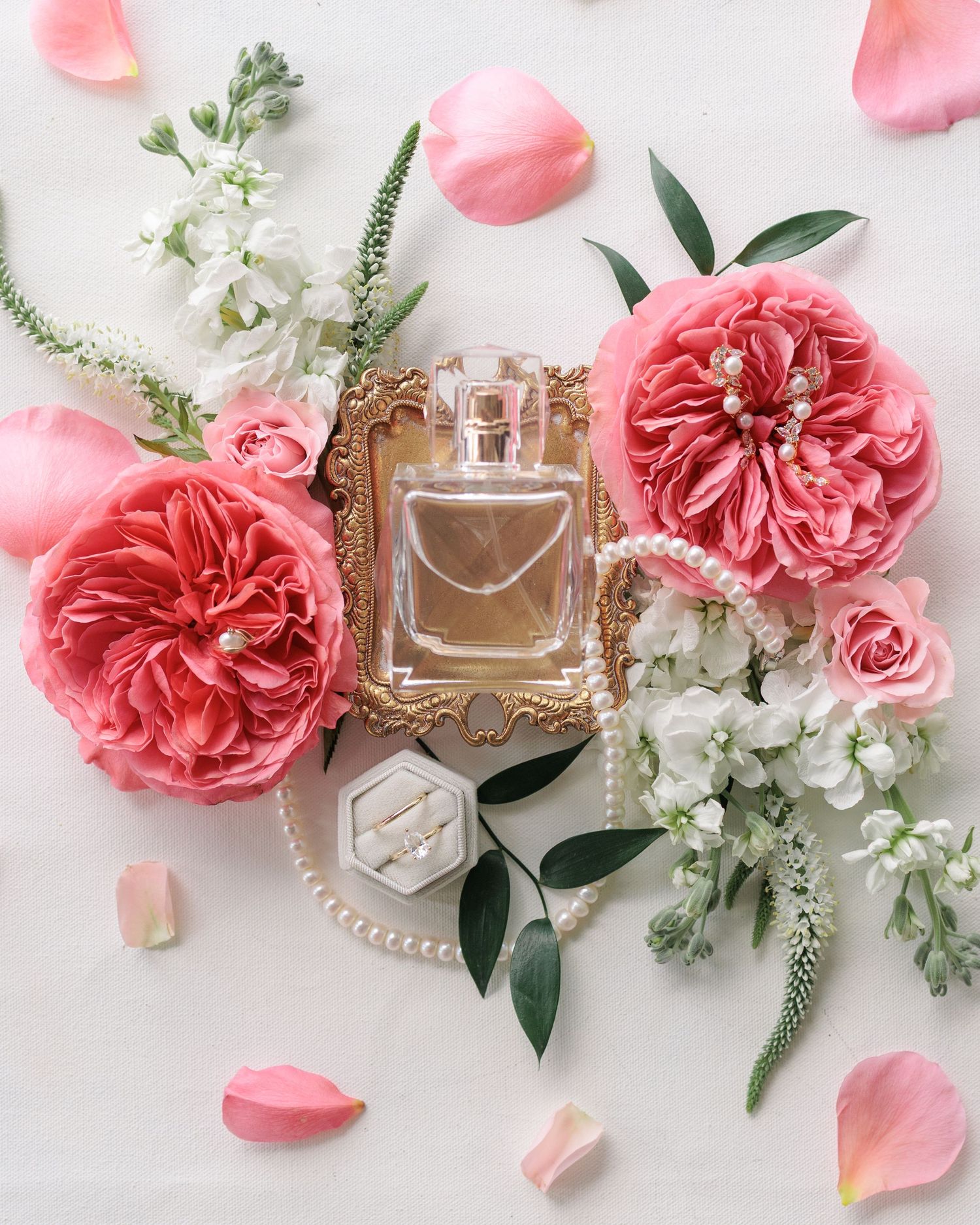 Editorial detail shot of a flat lay with wedding invitations, rings, and florals at a South Georgia venue.