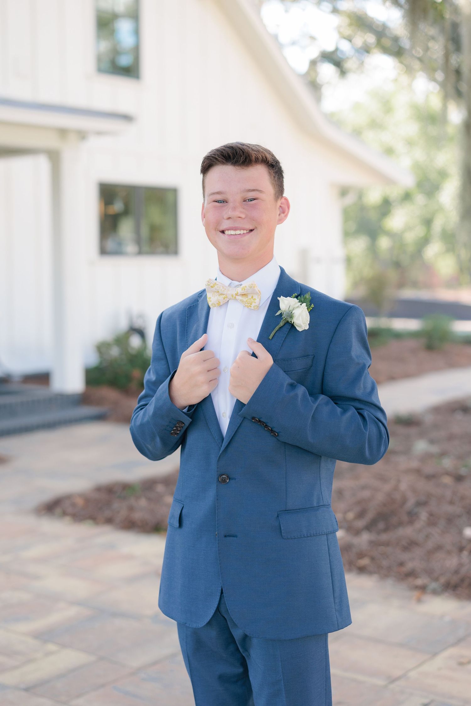 Sharp portrait of a high school guy dressed in a classic prom attire with a boutonniere, taken by a photographer based in Valdosta, GA.