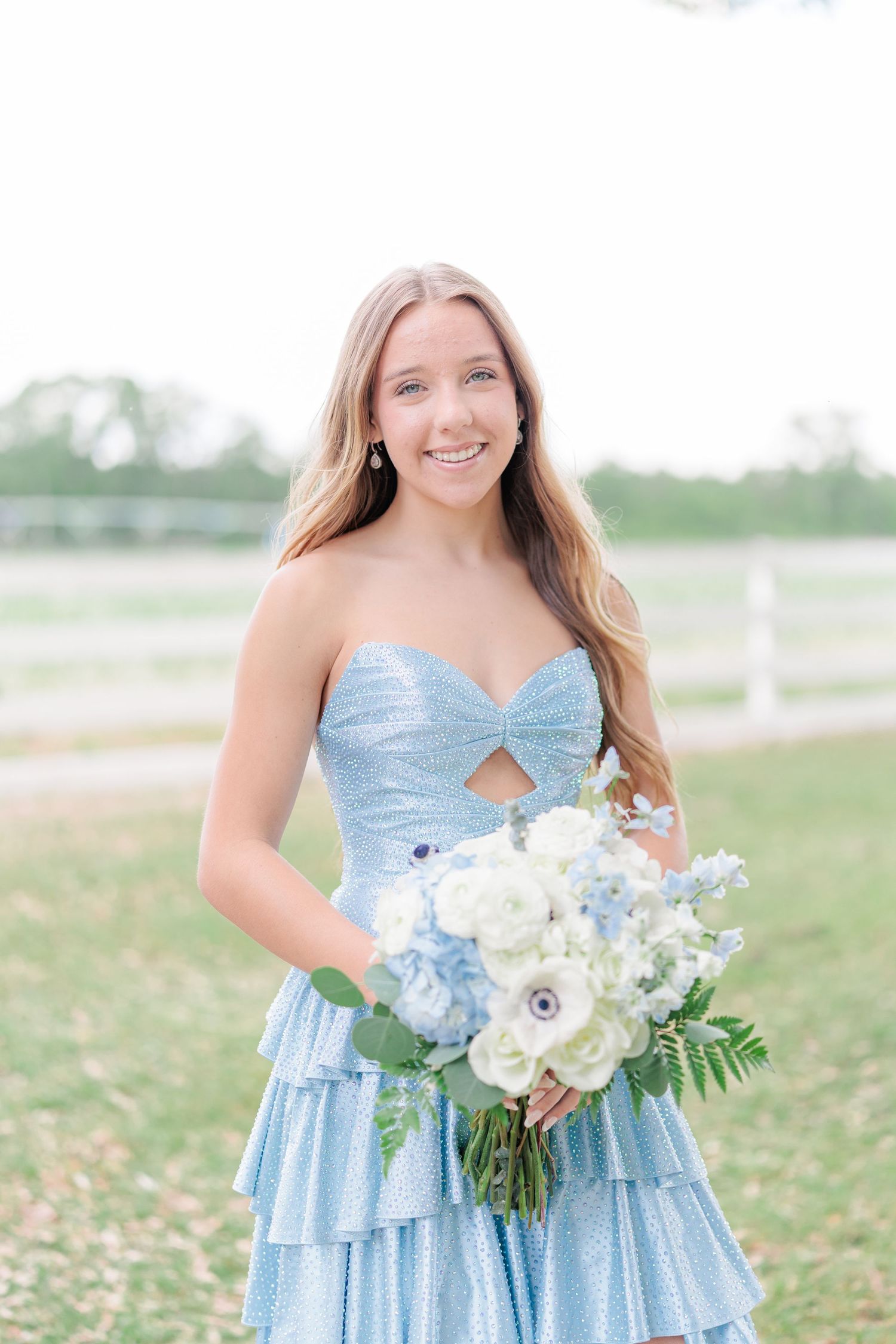 Beautiful portrait of a high school girl in her elegant prom dress holding a floral arrangement, taken by a photographer in Valdosta, GA.