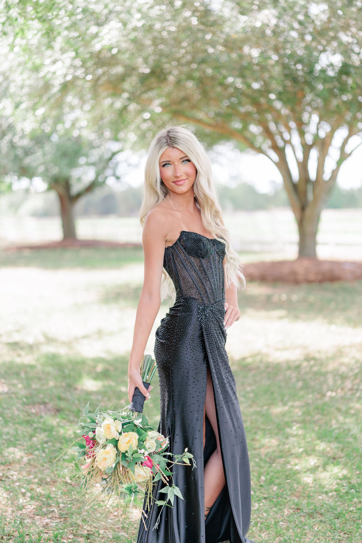 Beautiful portrait of a high school girl in her elegant prom dress holding a floral arrangement, taken by a photographer in Valdosta, GA.