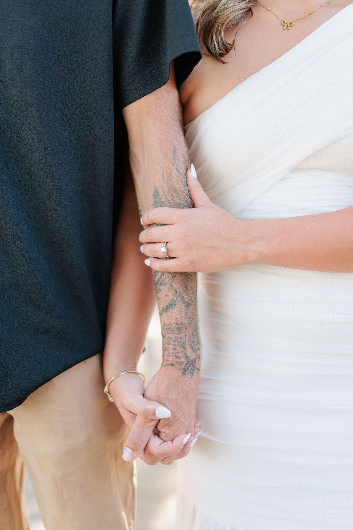 Couple embracing during engagement session in South Georgia highlighting couple's chemistry and showing off the engagement ring.