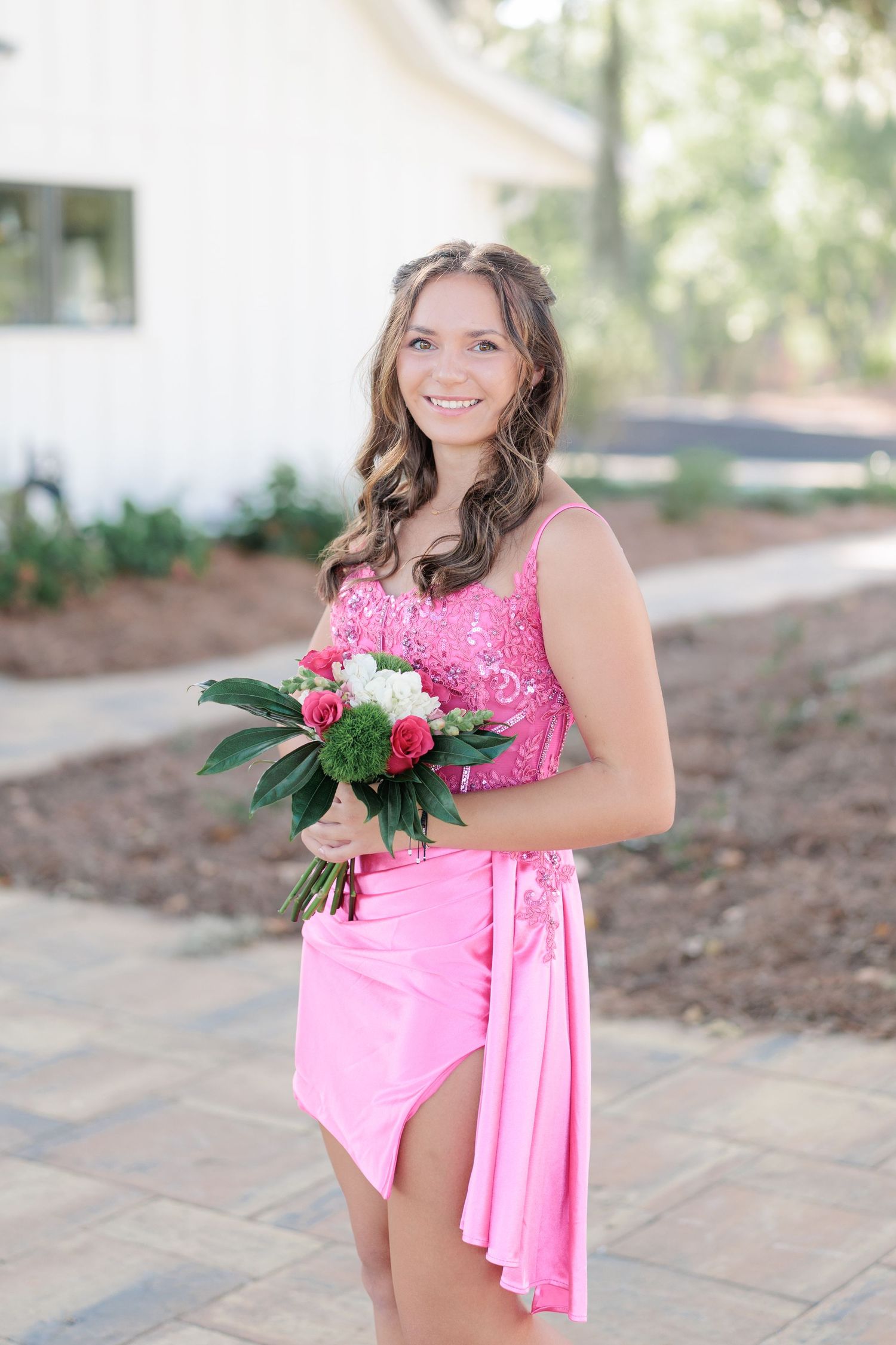 Beautiful portrait of a high school girl in her elegant prom dress holding a floral arrangement, taken by a photographer in Valdosta, GA.
