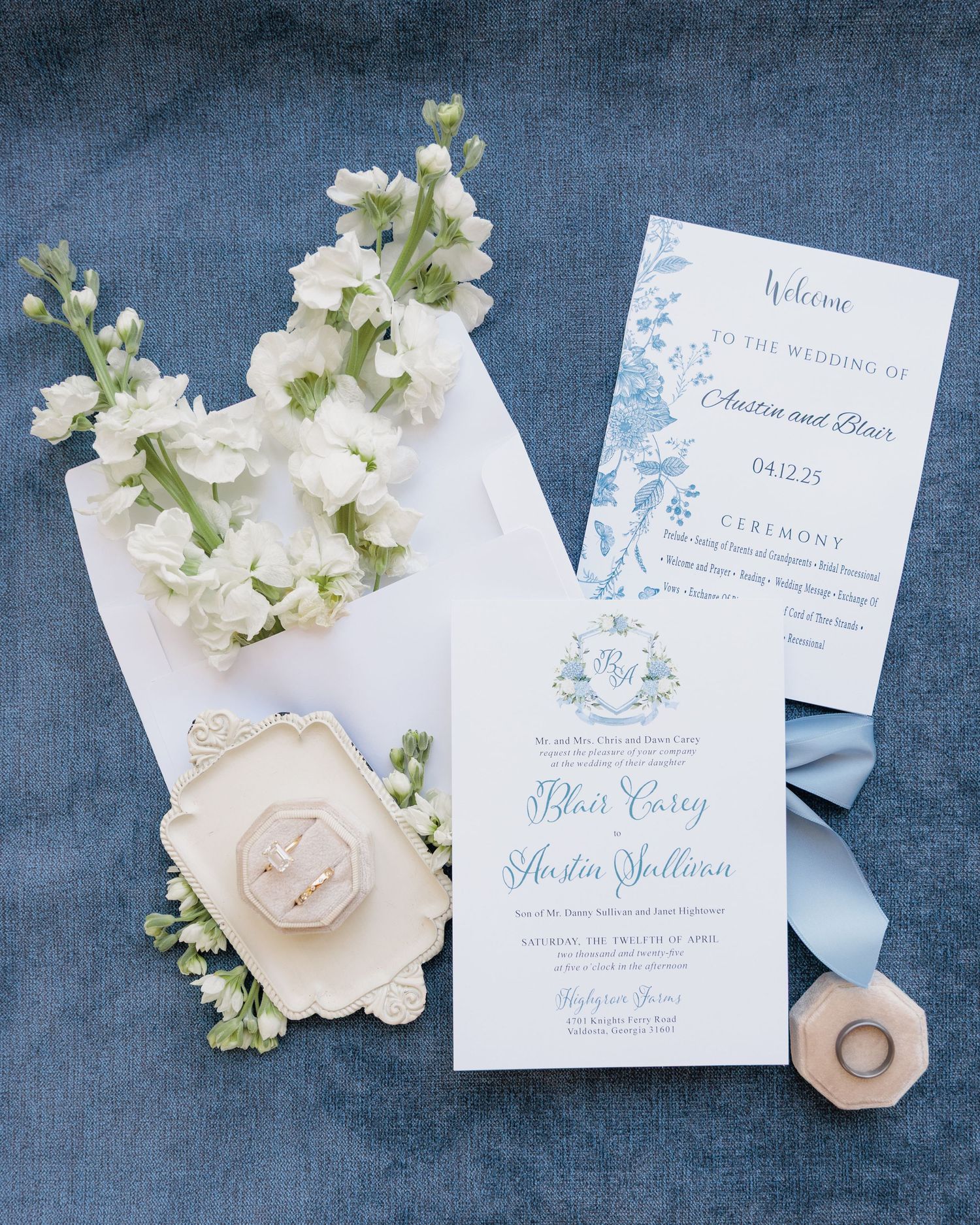 Editorial detail shot of a flat lay with wedding invitations, rings, and florals at a South Georgia venue.