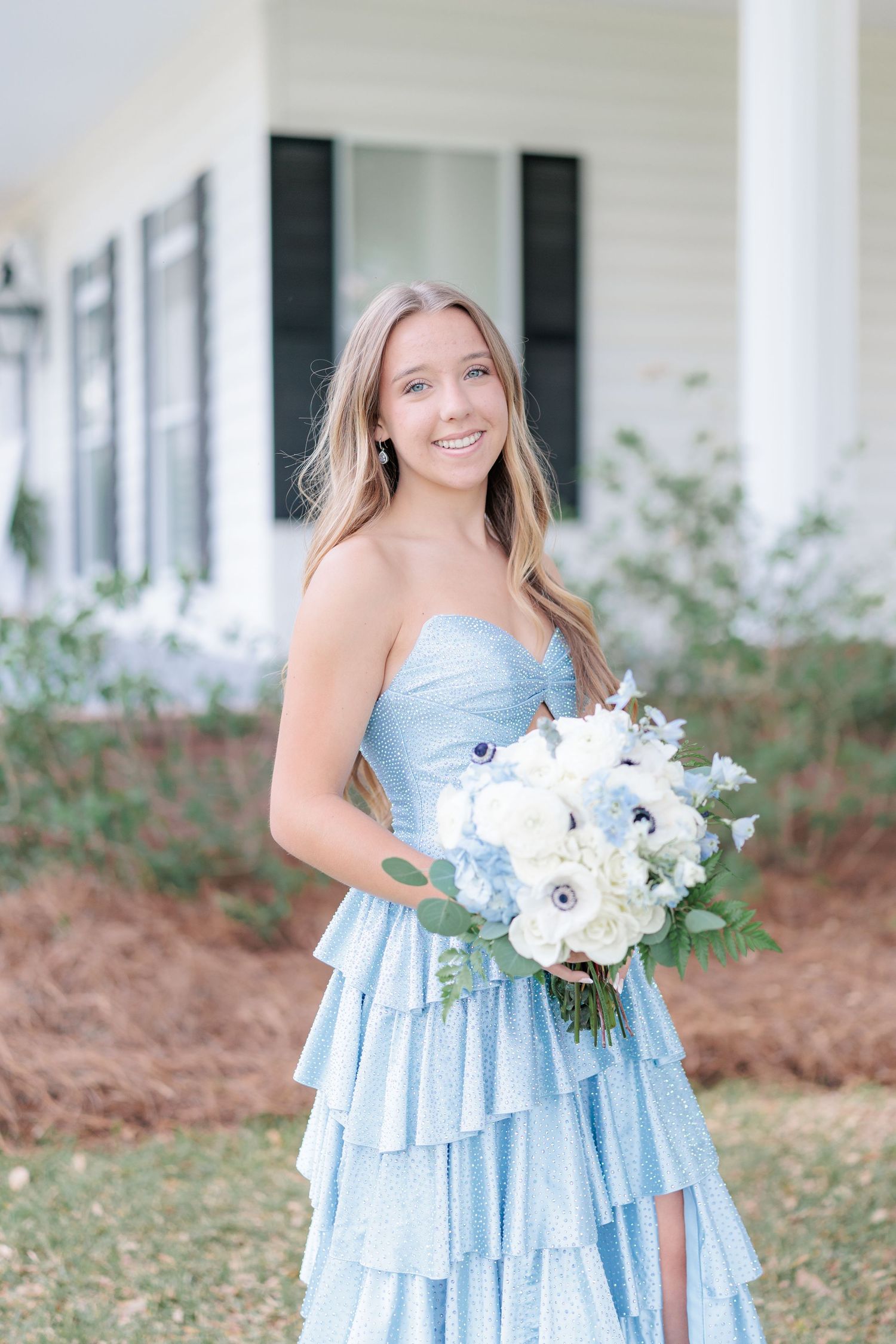 Beautiful portrait of a high school girl in her elegant prom dress holding a floral arrangement, taken by a photographer in Valdosta, GA.
