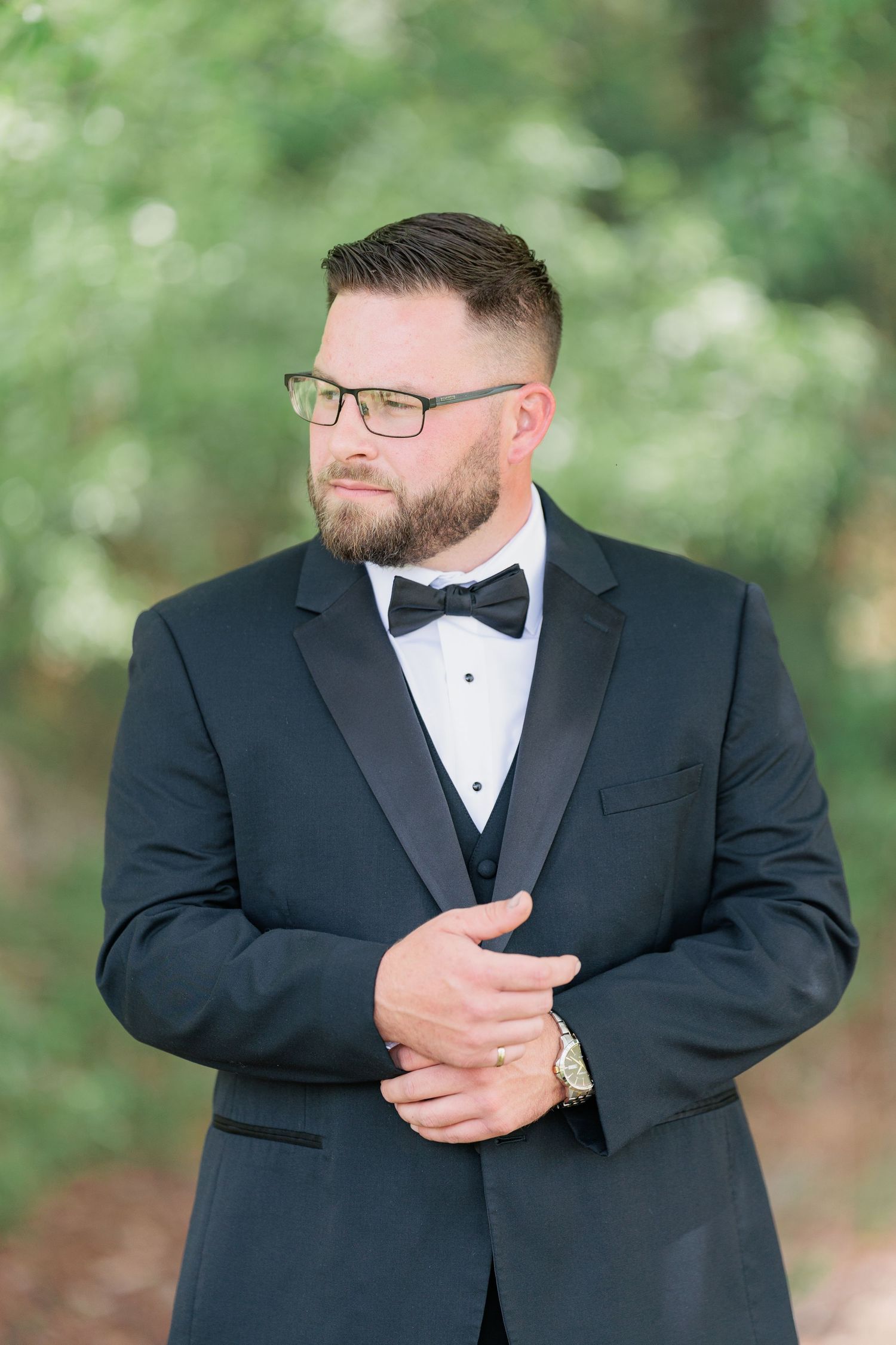 Sharp portrait of a groom adjusting his classic black tuxedo before a South Georgia wedding ceremony in Valdosta.
