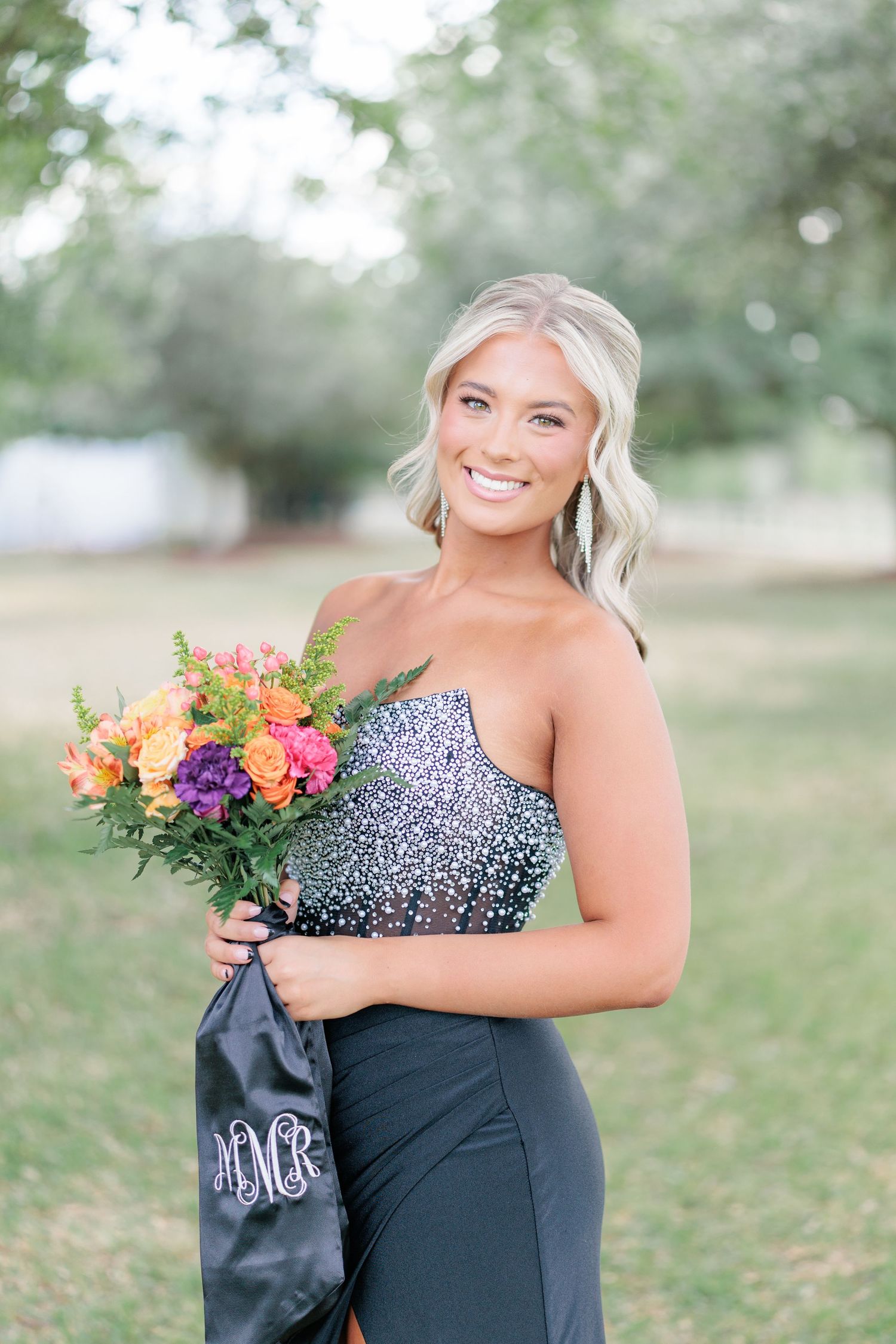 Beautiful portrait of a high school girl in her elegant prom dress holding a floral arrangement, taken by a photographer in Valdosta, GA.