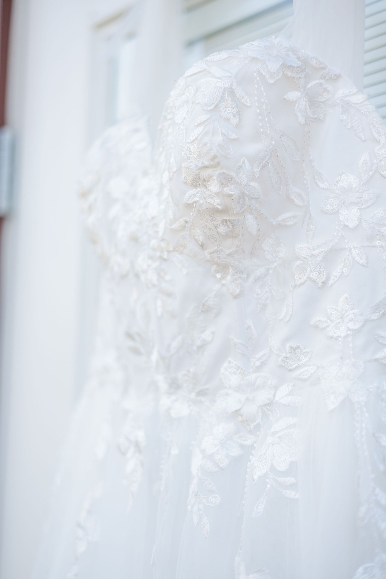 Details photo of wedding dress before the bride puts it on, highlighting the detail in the design of the dress.