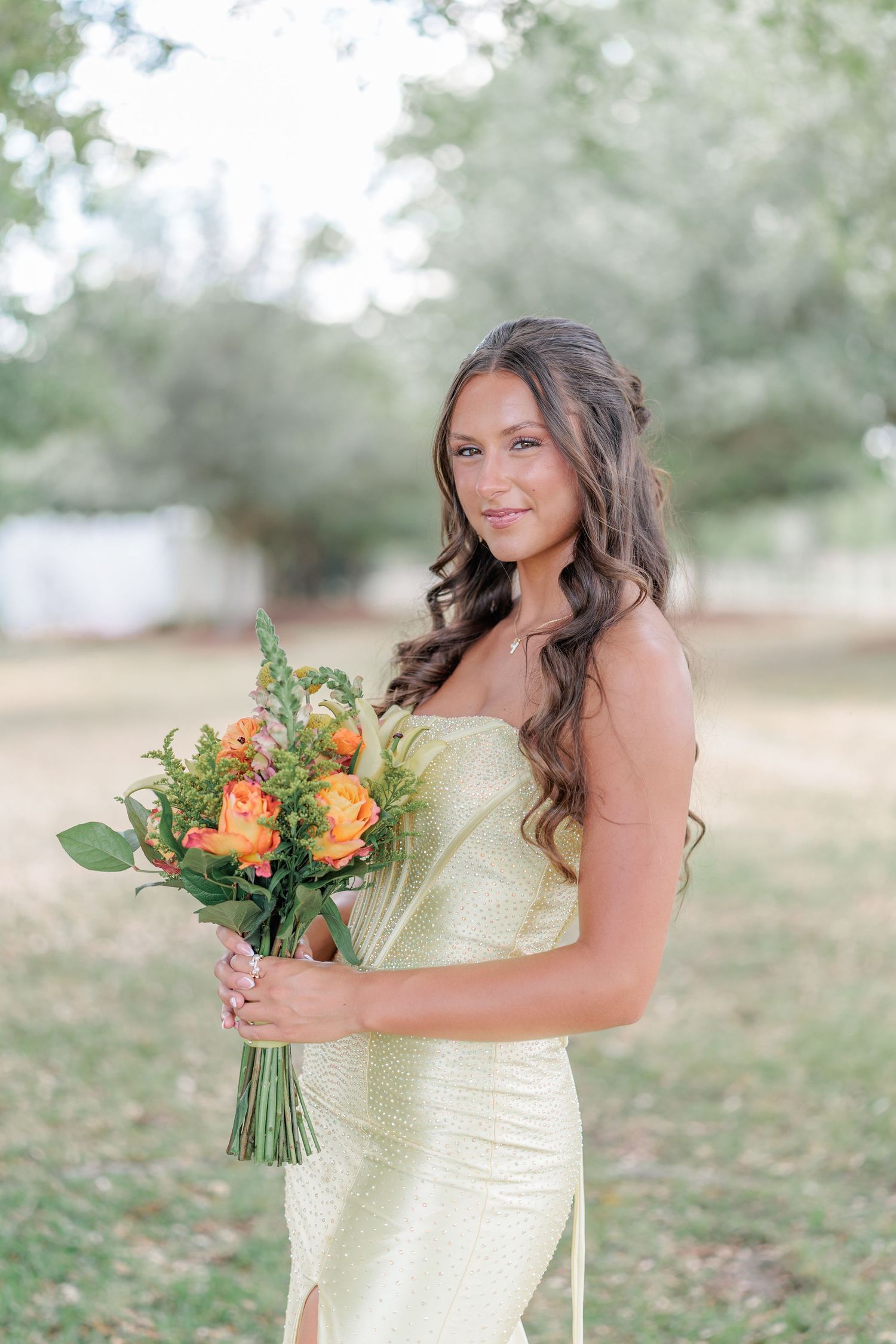 Beautiful portrait of a high school girl in her elegant prom dress holding a floral arrangement, taken by a photographer in Valdosta, GA.