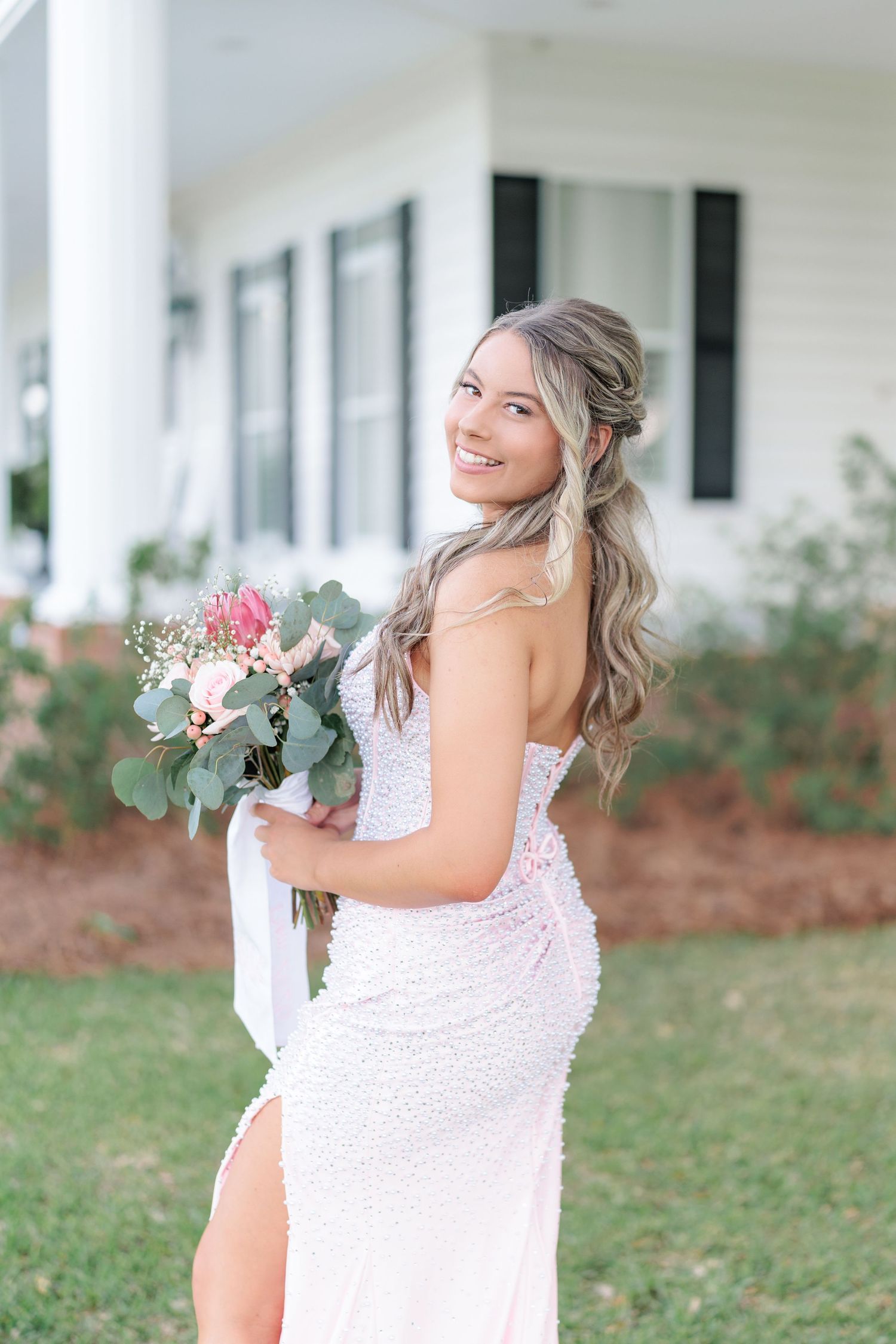 Beautiful portrait of a high school girl in her elegant prom dress holding a floral arrangement, taken by a photographer in Valdosta, GA.