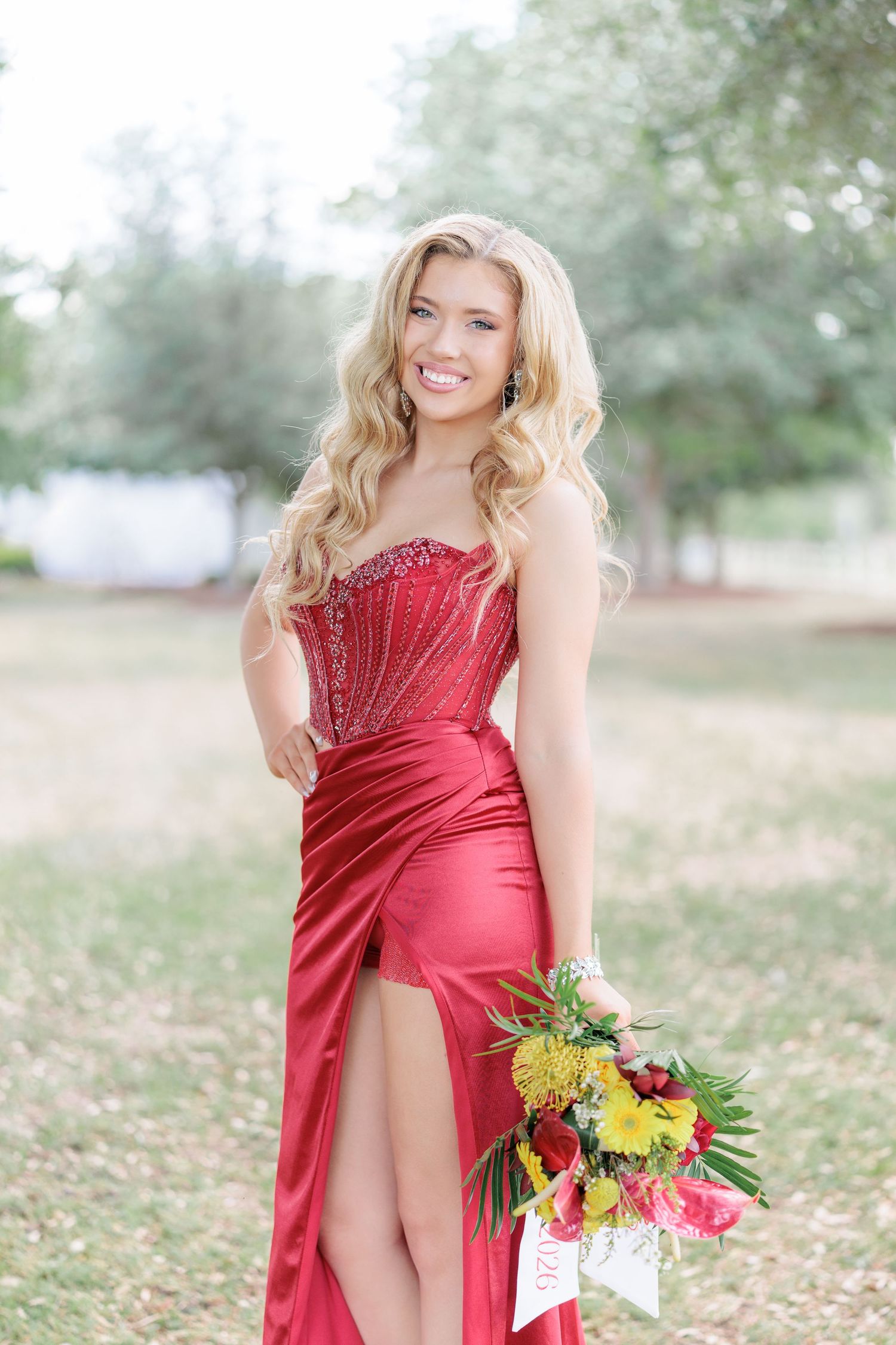 Beautiful portrait of a high school girl in her elegant prom dress holding a floral arrangement, taken by a photographer in Valdosta, GA.