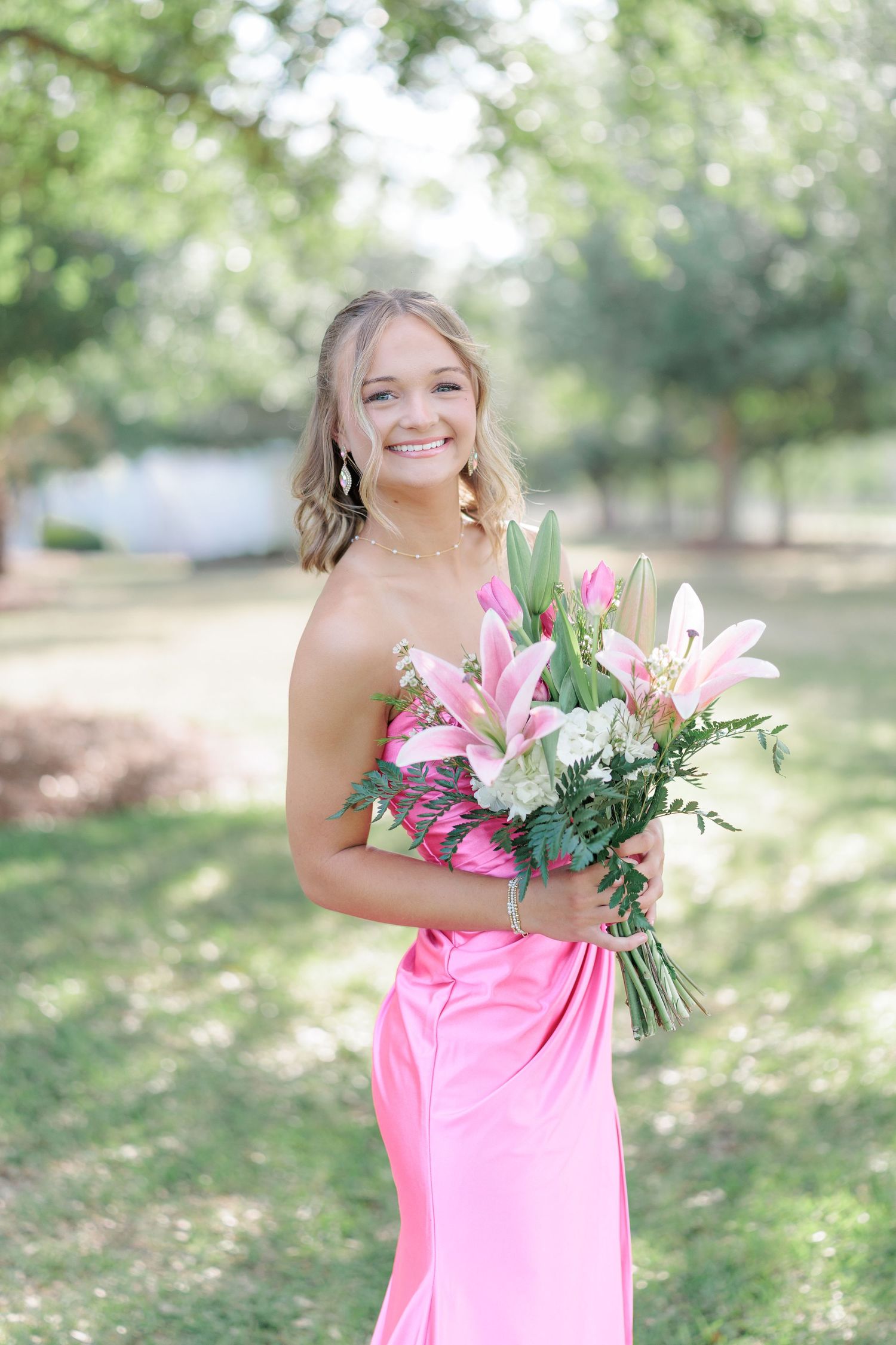 Beautiful portrait of a high school girl in her elegant prom dress holding a floral arrangement, taken by a photographer in Valdosta, GA.