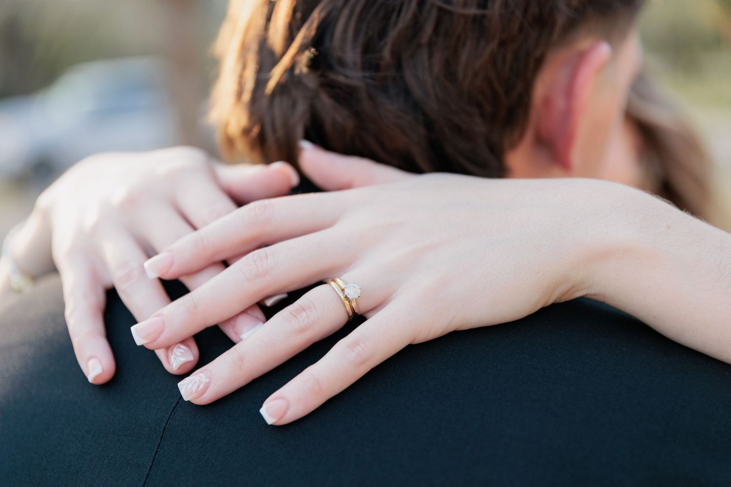 Couple embrace during their wedding day, highlighting the bride's wedding rings. Taken by a photographer based in Valdosta, GA.