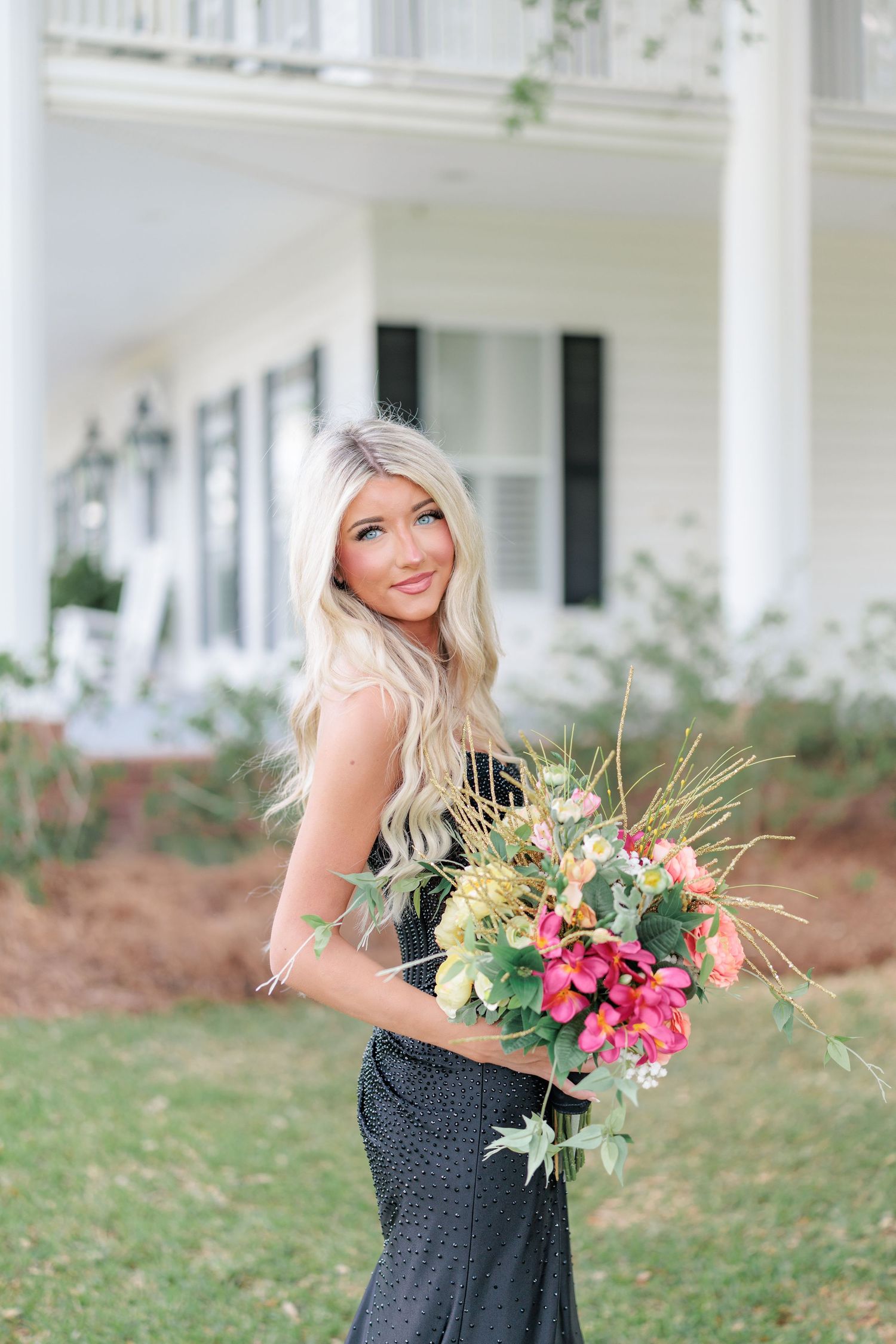 Beautiful portrait of a high school girl in her elegant prom dress holding a floral arrangement, taken by a photographer in Valdosta, GA.