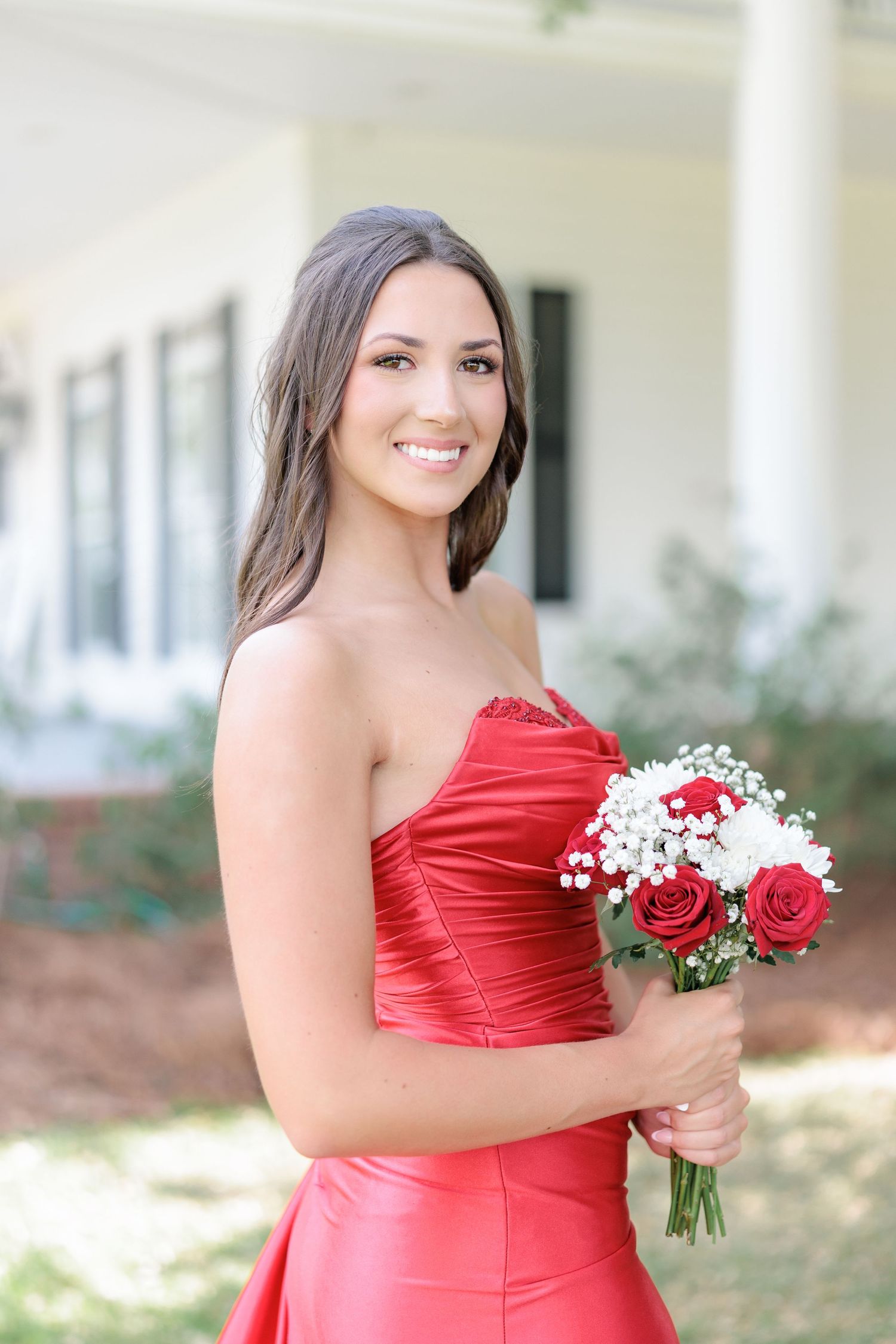 Beautiful portrait of a high school girl in her elegant prom dress holding a floral arrangement, taken by a photographer in Valdosta, GA.