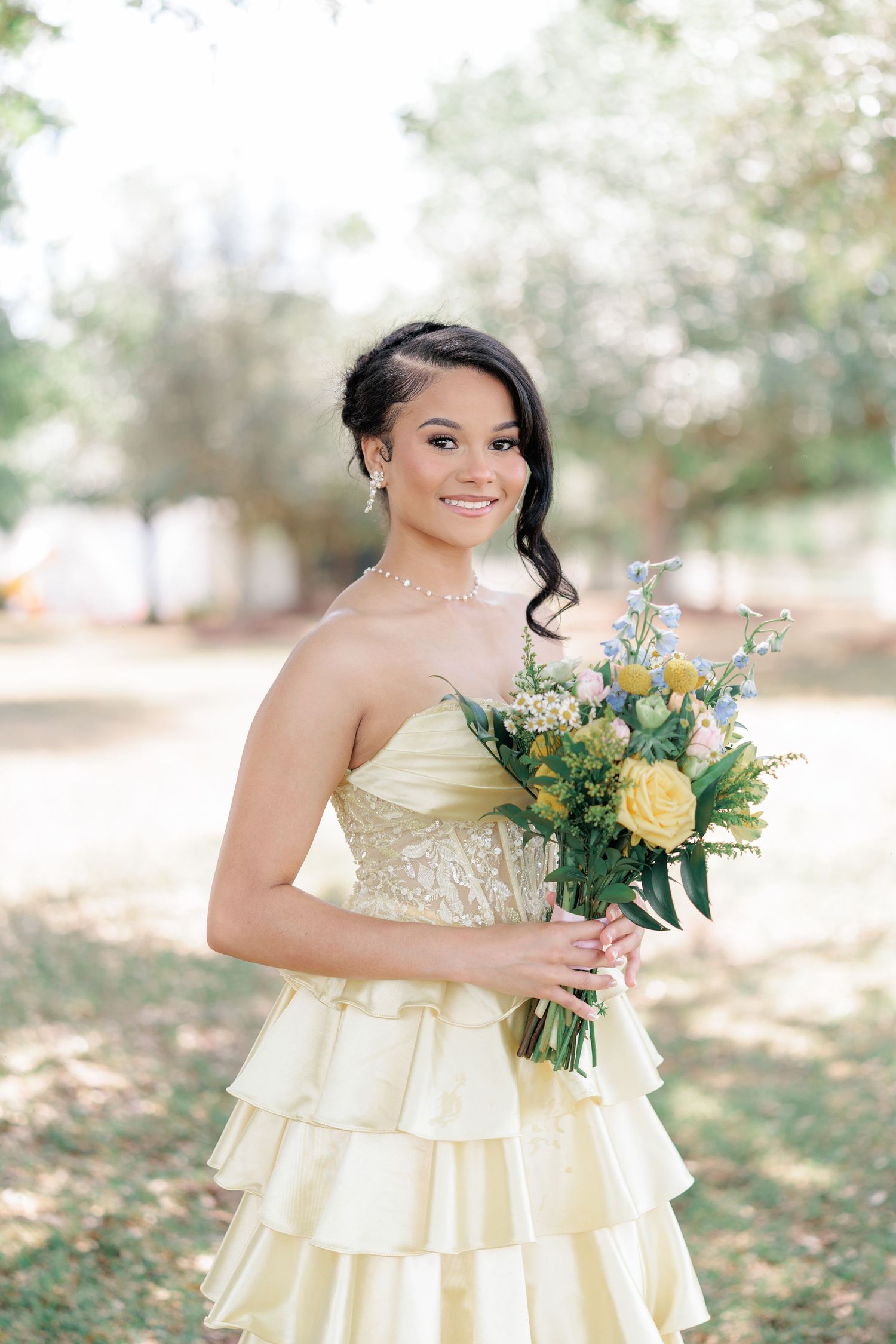 Beautiful portrait of a high school girl in her elegant prom dress holding a floral arrangement, taken by a photographer in Valdosta, GA.