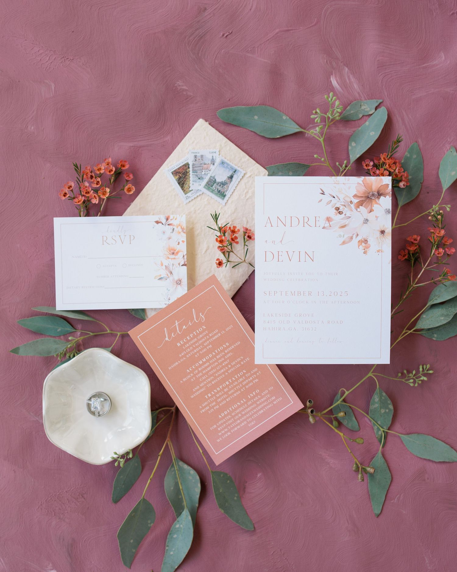 Editorial detail shot of a flat lay with wedding invitations, rings, and florals at a South Georgia venue.