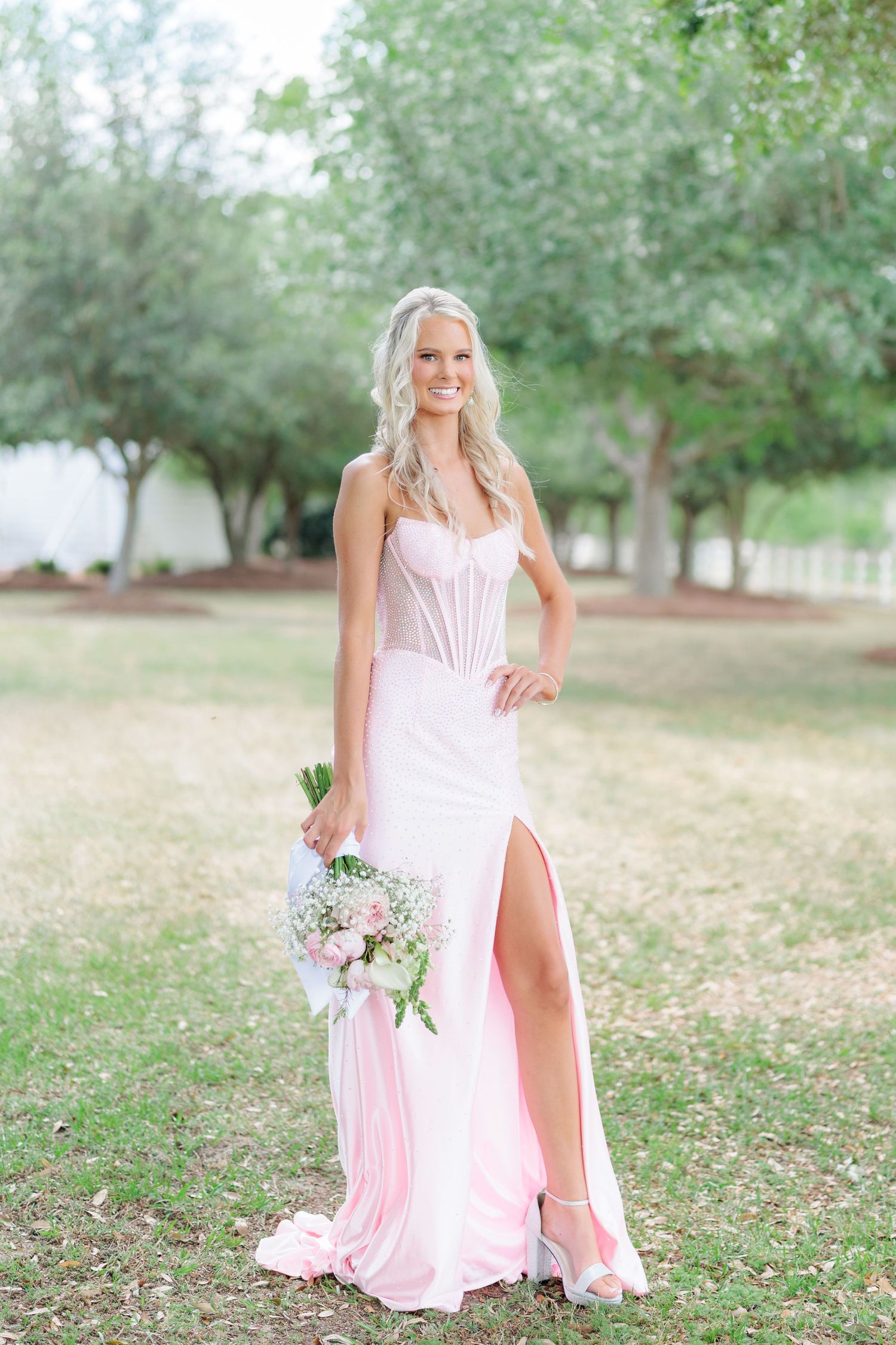 Beautiful portrait of a high school girl in her elegant prom dress holding a floral arrangement, taken by a photographer in Valdosta, GA.