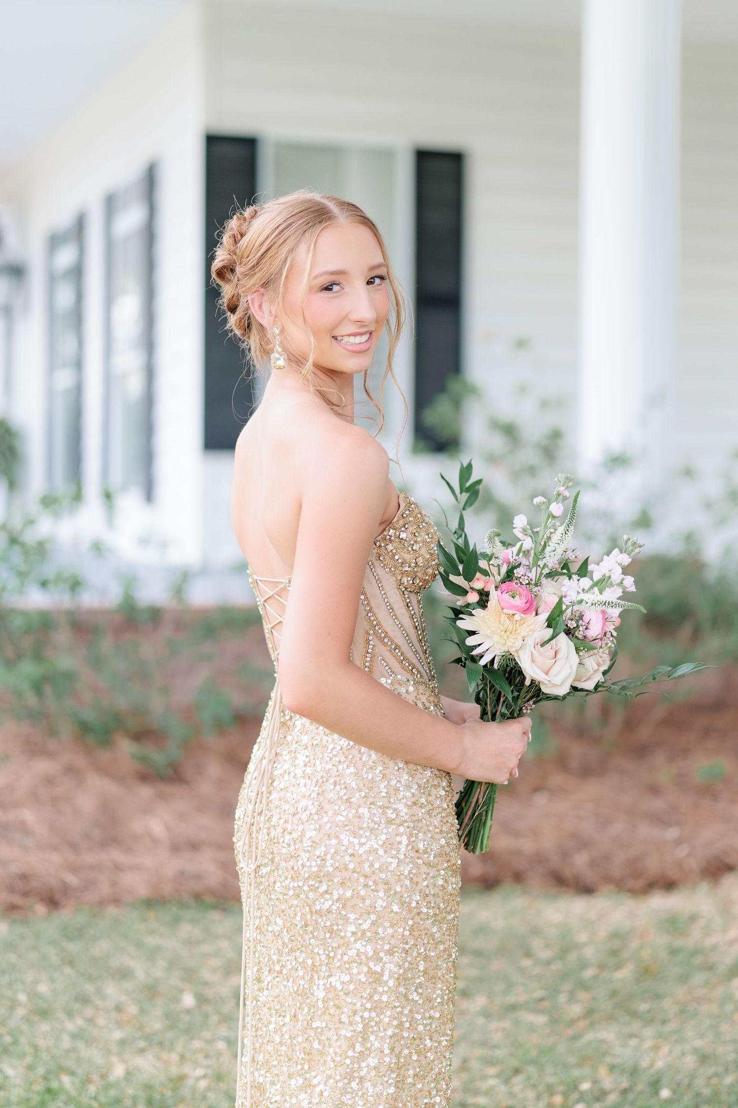 Beautiful portrait of a high school girl in her elegant prom dress holding a floral arrangement, taken by a photographer in Valdosta, GA.