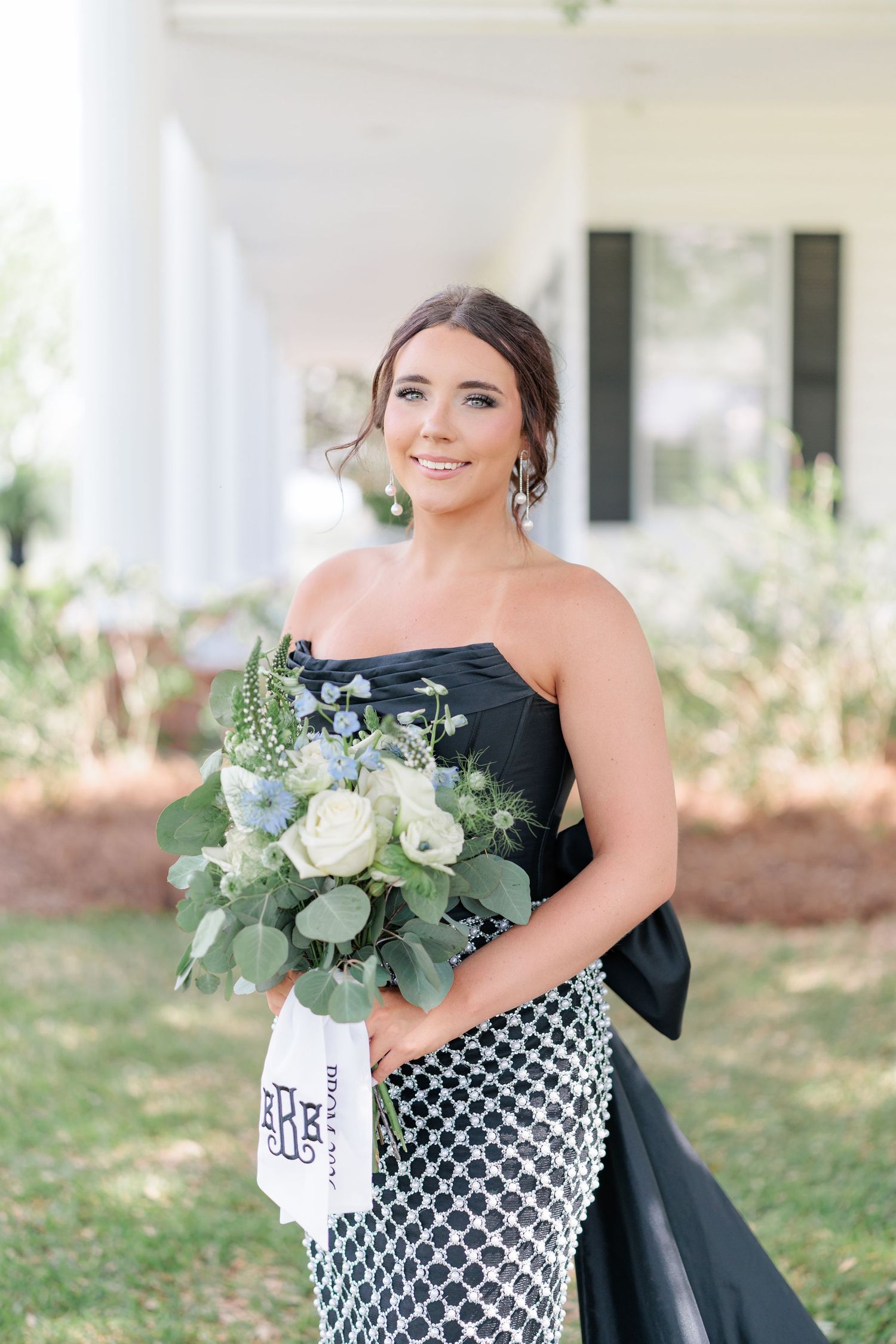Beautiful portrait of a high school girl in her elegant prom dress holding a floral arrangement, taken by a photographer in Valdosta, GA.