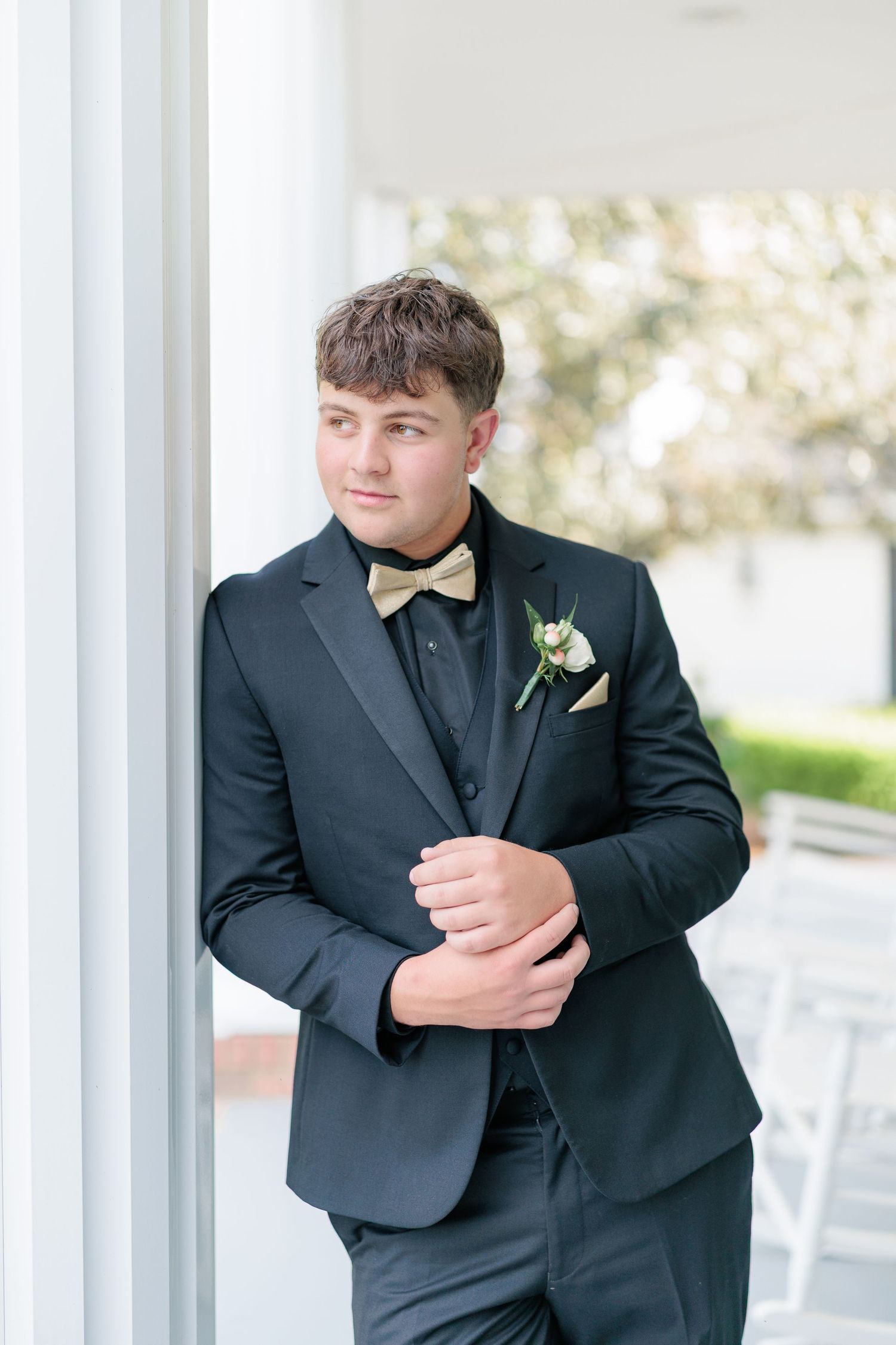 Sharp portrait of a high school guy dressed in a classic prom attire with a boutonniere, taken by a photographer based in Valdosta, GA.