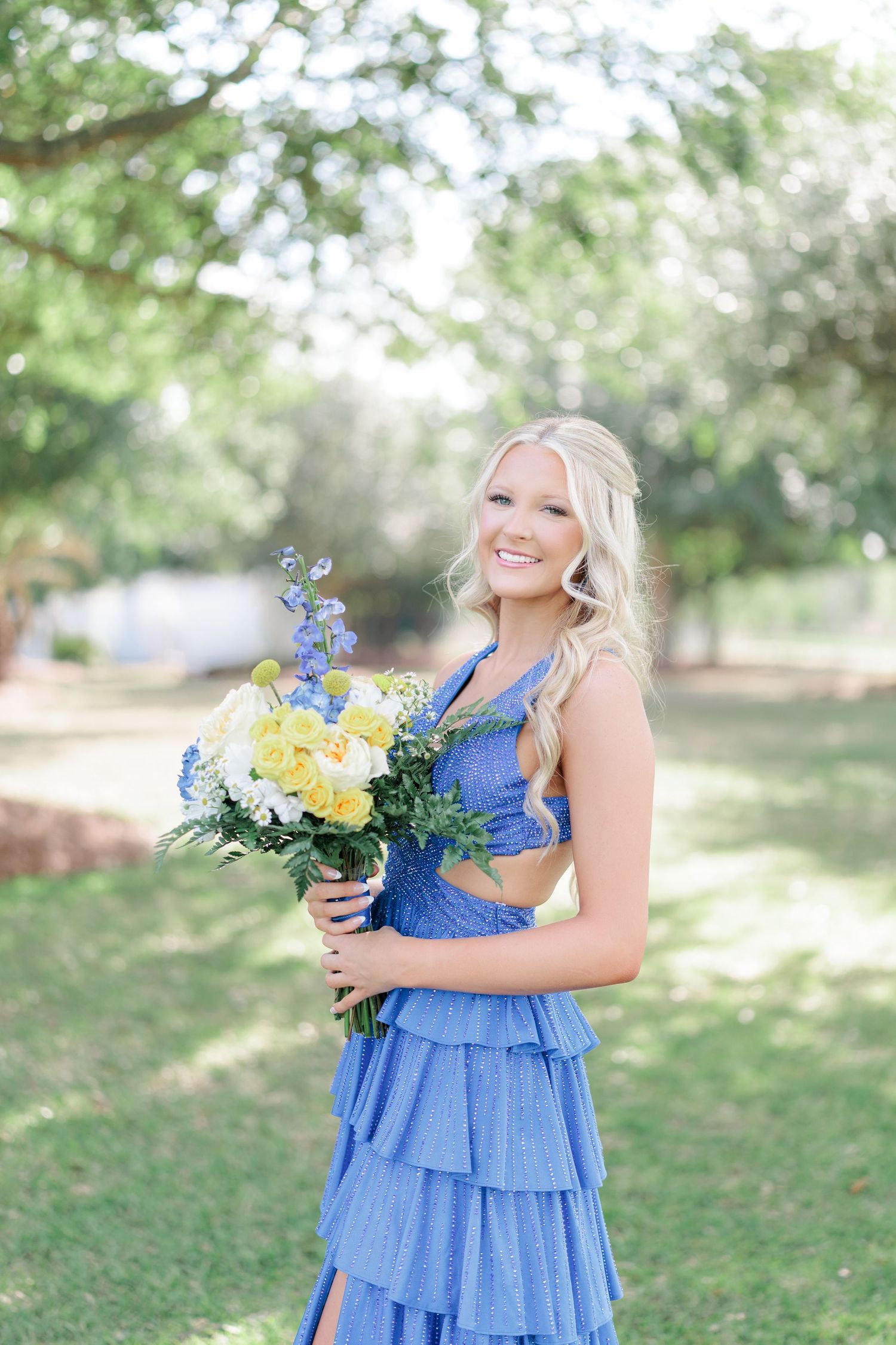 Beautiful portrait of a high school girl in her elegant prom dress holding a floral arrangement, taken by a photographer in Valdosta, GA.